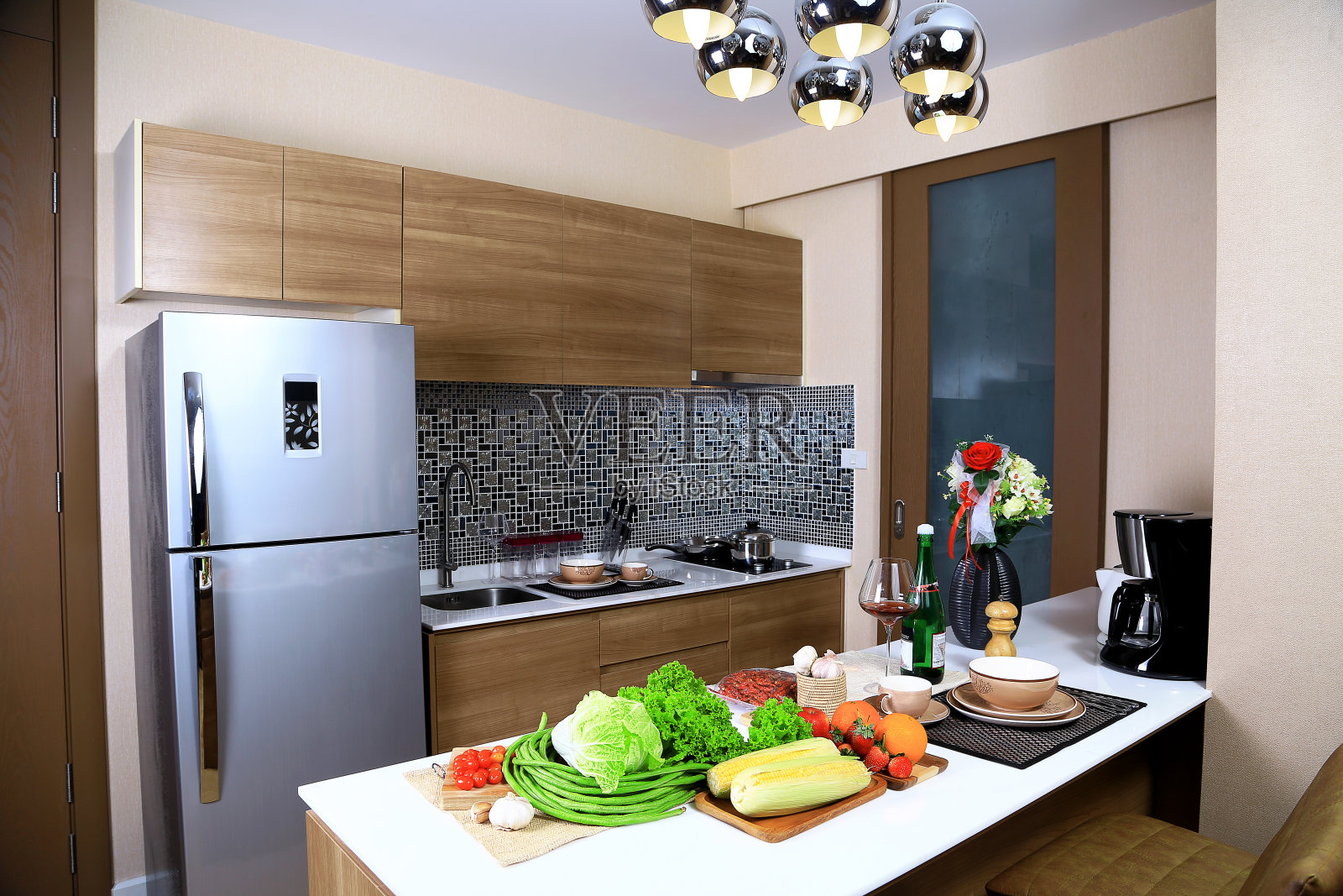 公寓厨房的豪华内饰设计，有一些蔬菜和水果。如生菜，大白菜，长豆，樱桃番茄，大蒜，酒杯，天花板上有温暖的灯光。作为厨房设计背景。照片摄影图片
