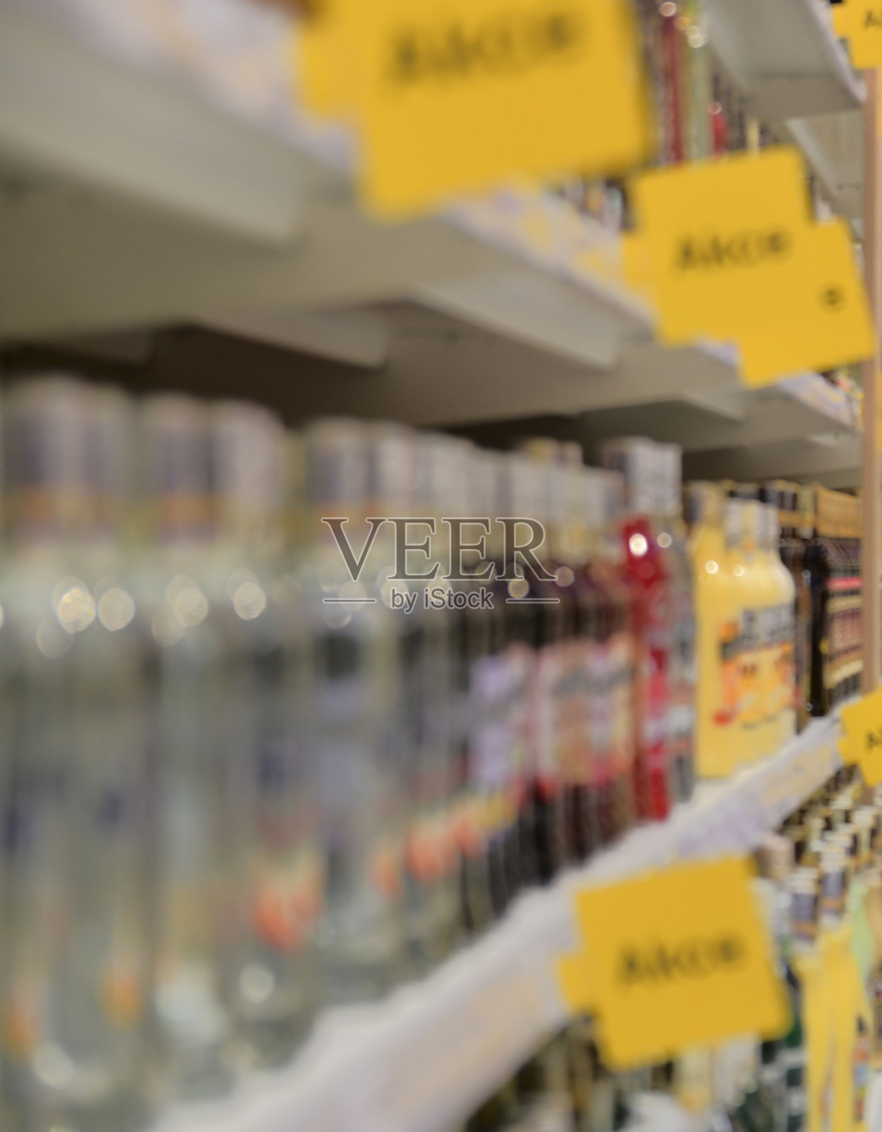 在欧洲的零售店里，酒精、烈性酒的瓶子被弄得模糊不清。超市过道，散焦背景照片摄影图片