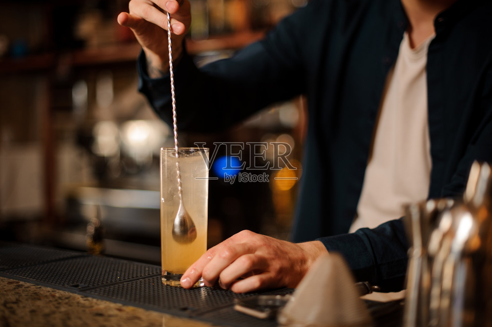 调酒员用手搅拌新鲜甜美的橙色夏季鸡尾酒照片摄影图片