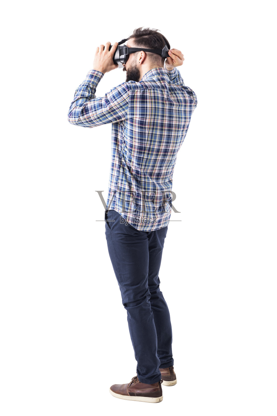 年轻的胡子潇洒的休闲男人戴上虚拟现实眼镜戴在头上。照片摄影图片