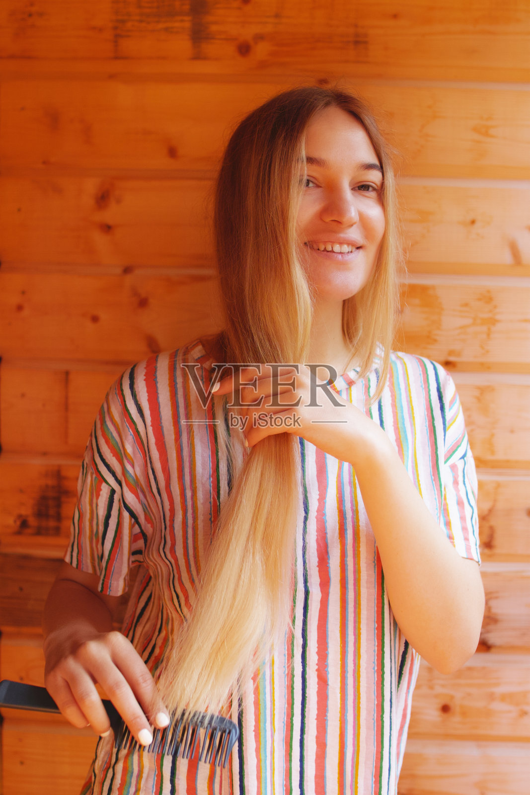 一个年轻的金发女人在山上的阳台上梳头发照片摄影图片