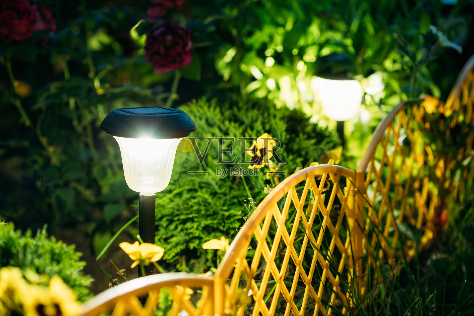 小型太阳能花园灯，花坛灯笼。花园的设计。太阳能灯照片摄影图片