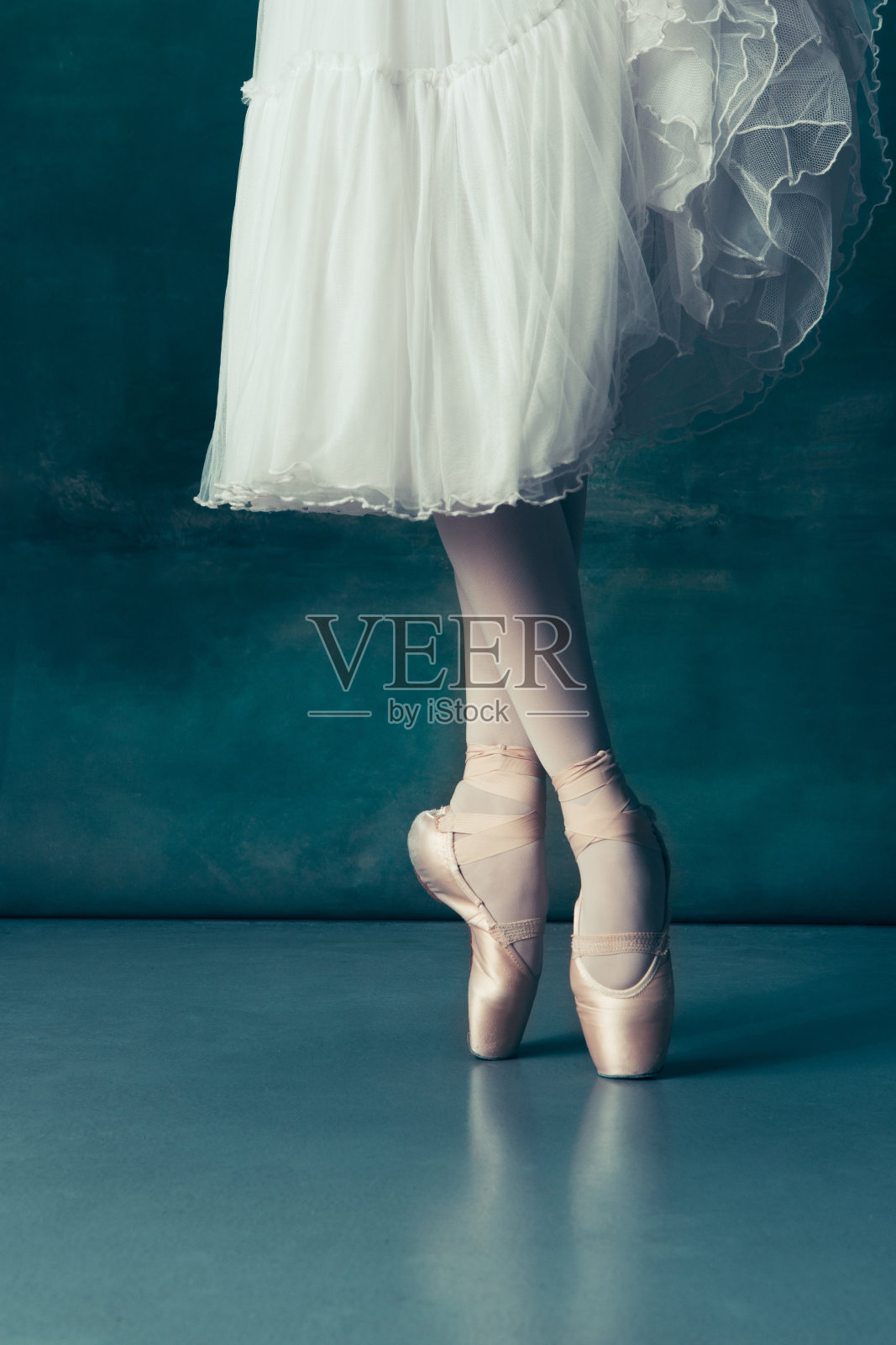 特写芭蕾舞者的脚尖放在灰色的木地板上照片摄影图片