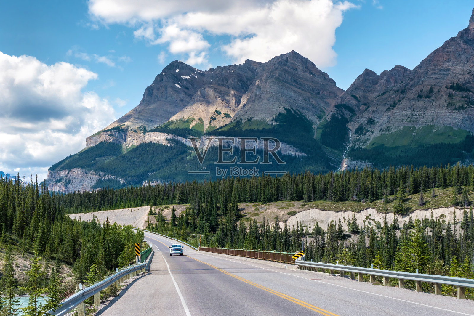 在加拿大阿尔伯塔省班夫和贾斯珀国家公园之间的冰原公路上行驶的车辆照片摄影图片