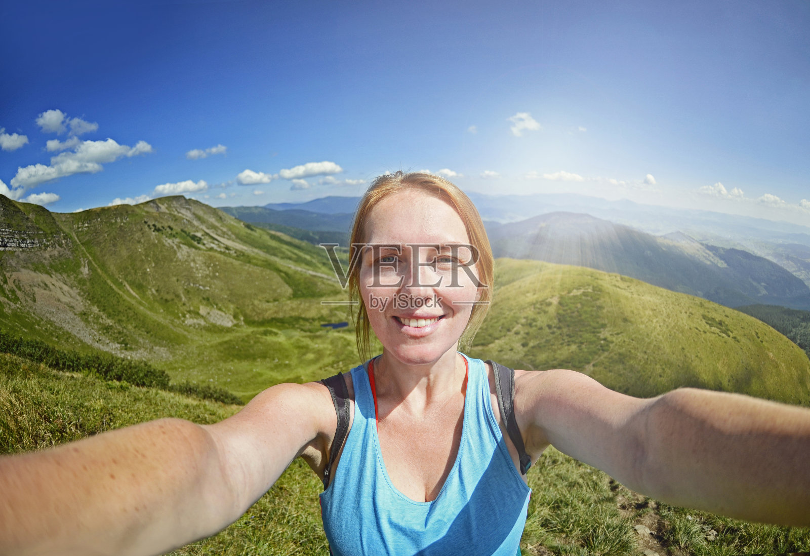 微笑的年轻女子在喀尔巴阡山脉的山顶自拍照片摄影图片