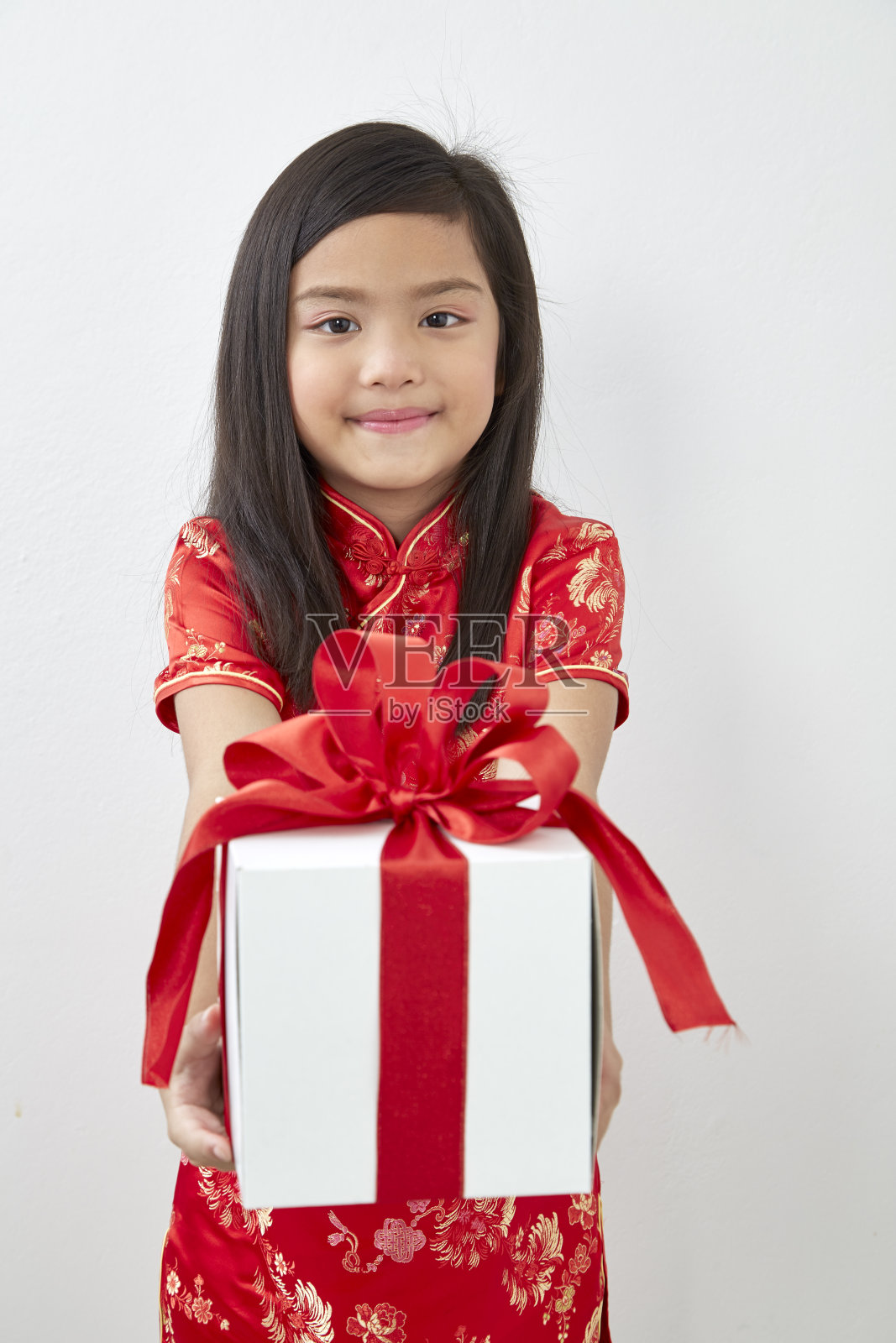 中国女孩8岁女孩与中国新年白色背景的礼盒照片摄影图片