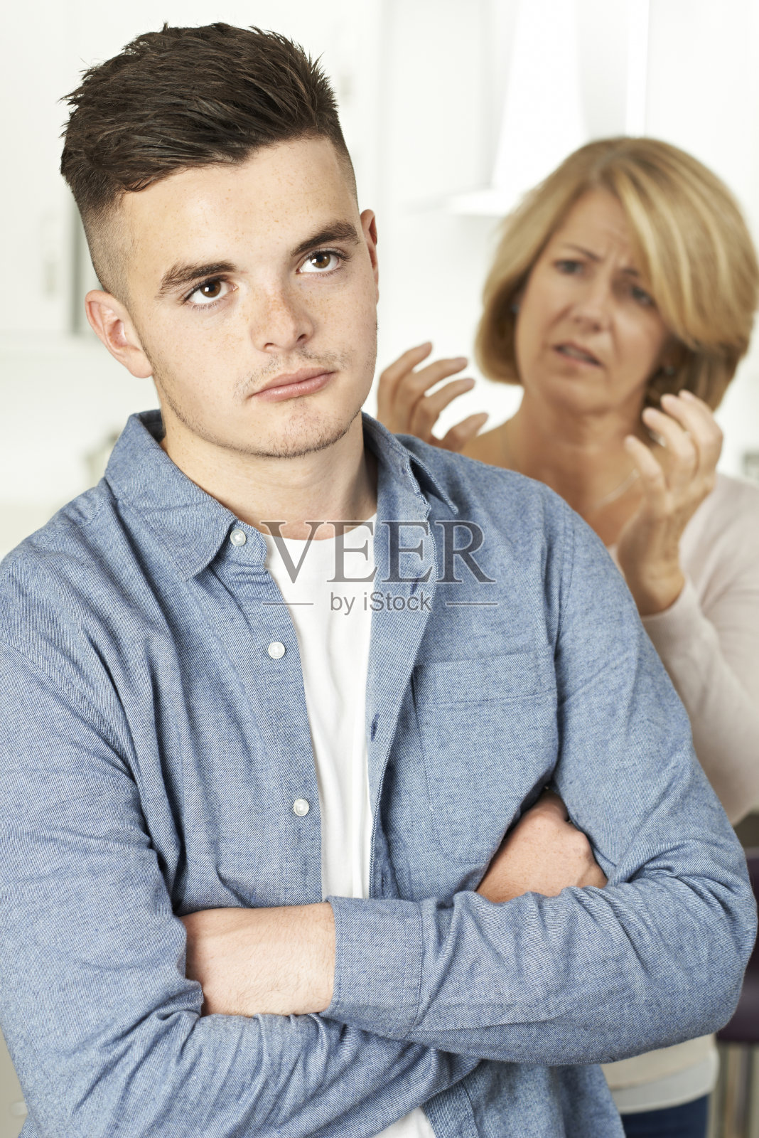 母亲在家里和十几岁的儿子争吵照片摄影图片