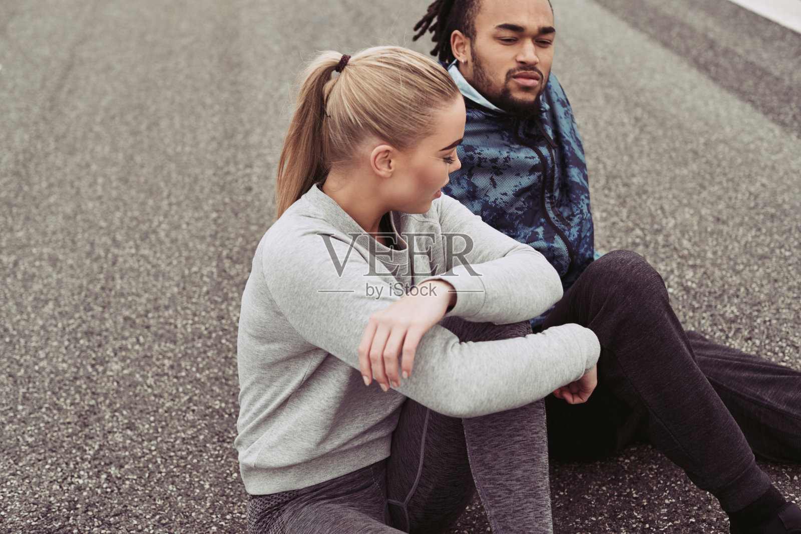 一对年轻夫妇在户外跑步后坐在马路上照片摄影图片
