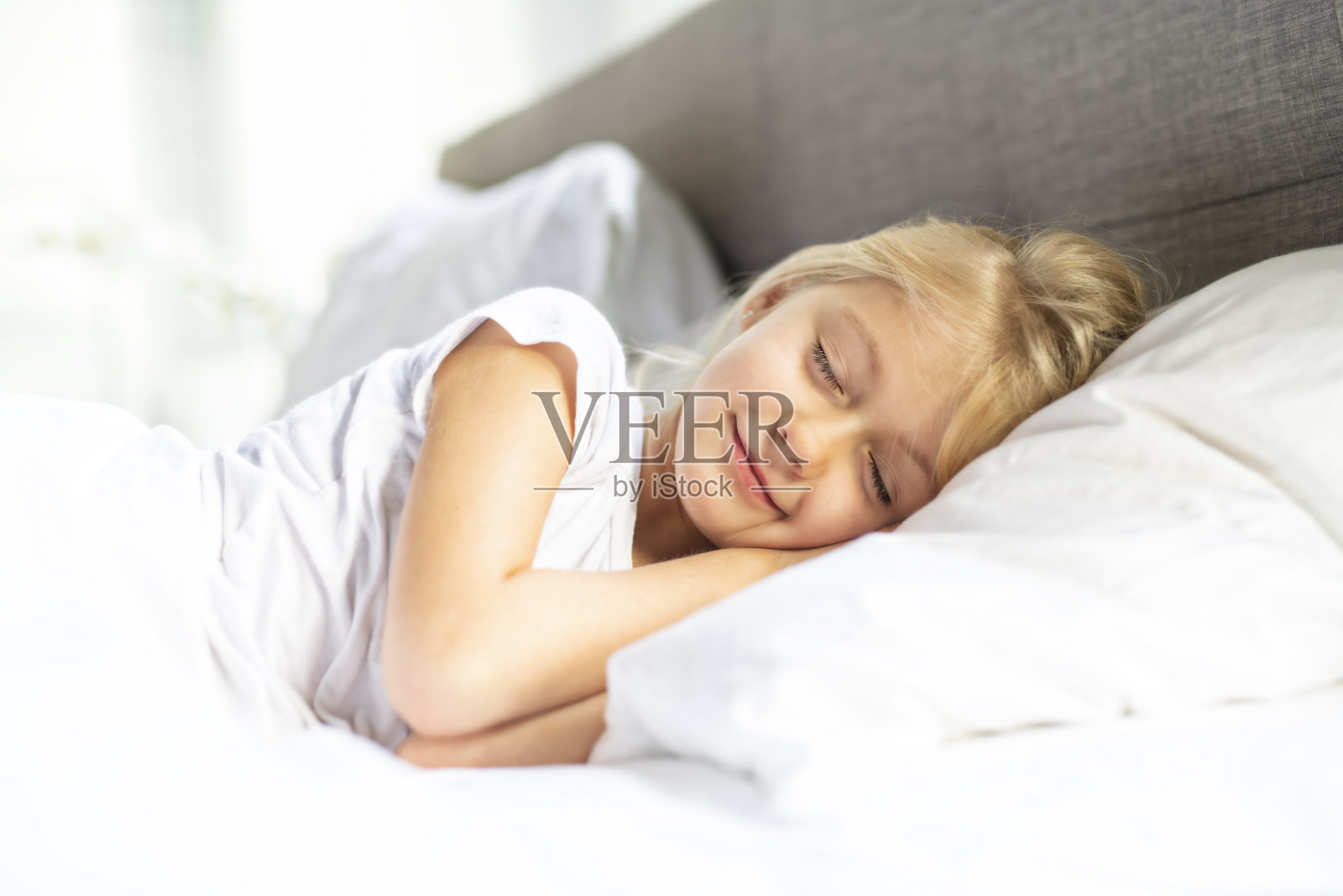 一个小女孩在床上睡觉，做着梦照片摄影图片