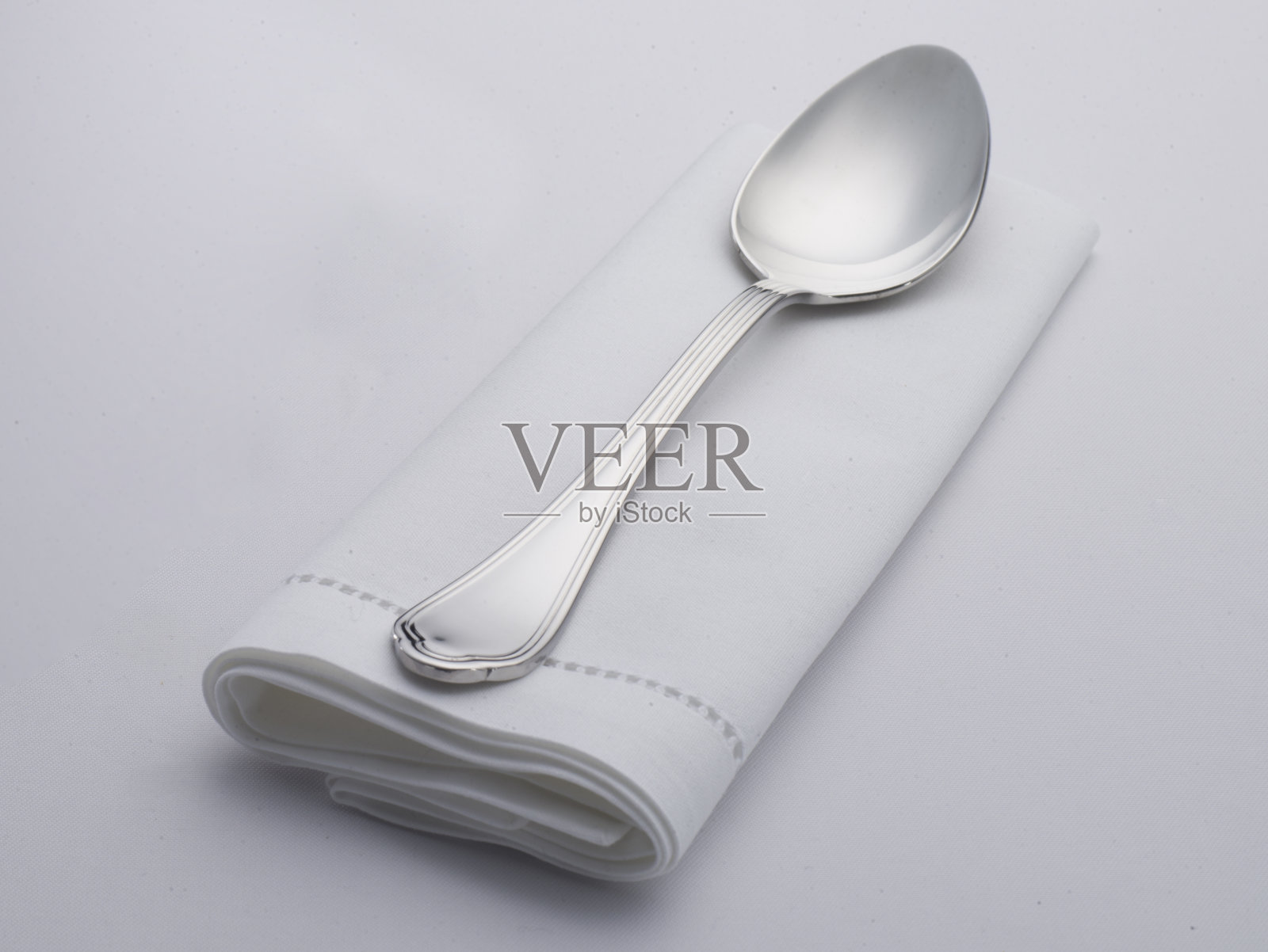空白的白色餐厅餐巾，用勺子做的模型照片摄影图片