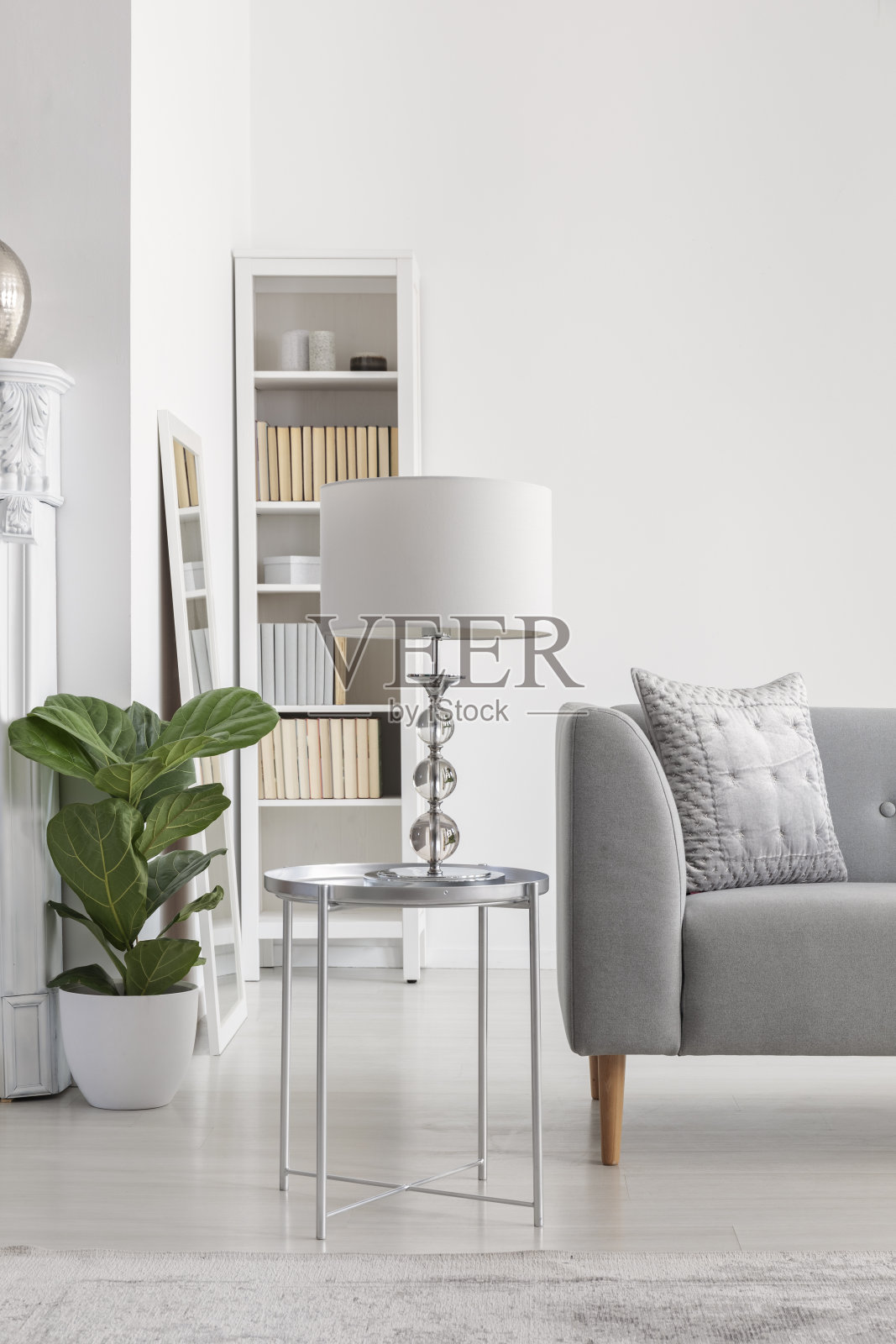 在宽敞的纽约风格的客厅里，灰色沙发旁边的小银桌上摆着优雅的白色台灯照片摄影图片