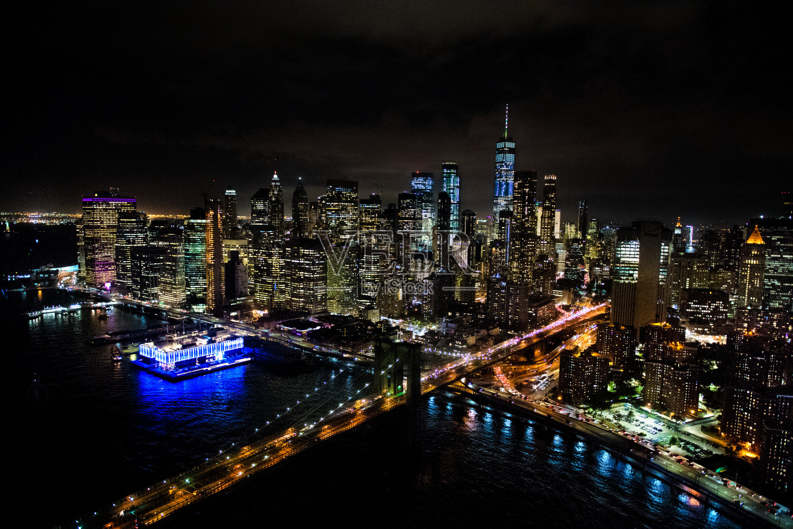 纽约布鲁克林大桥的鸟瞰图，从一架直升机在东河上方拍摄的夜晚照片摄影图片