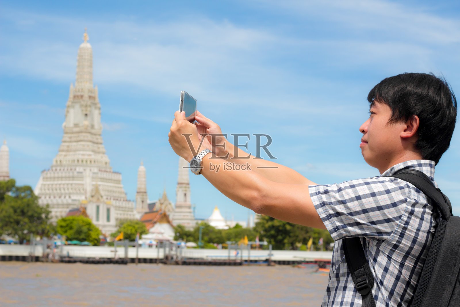 游客拿着手机拍照你自己微笑与Wat Arun在泰国。照片摄影图片
