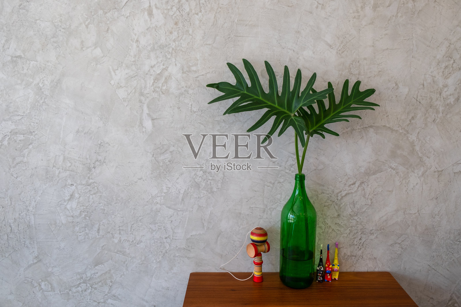 绿色植物自然的木桌与灰色的混凝土墙背景。照片摄影图片