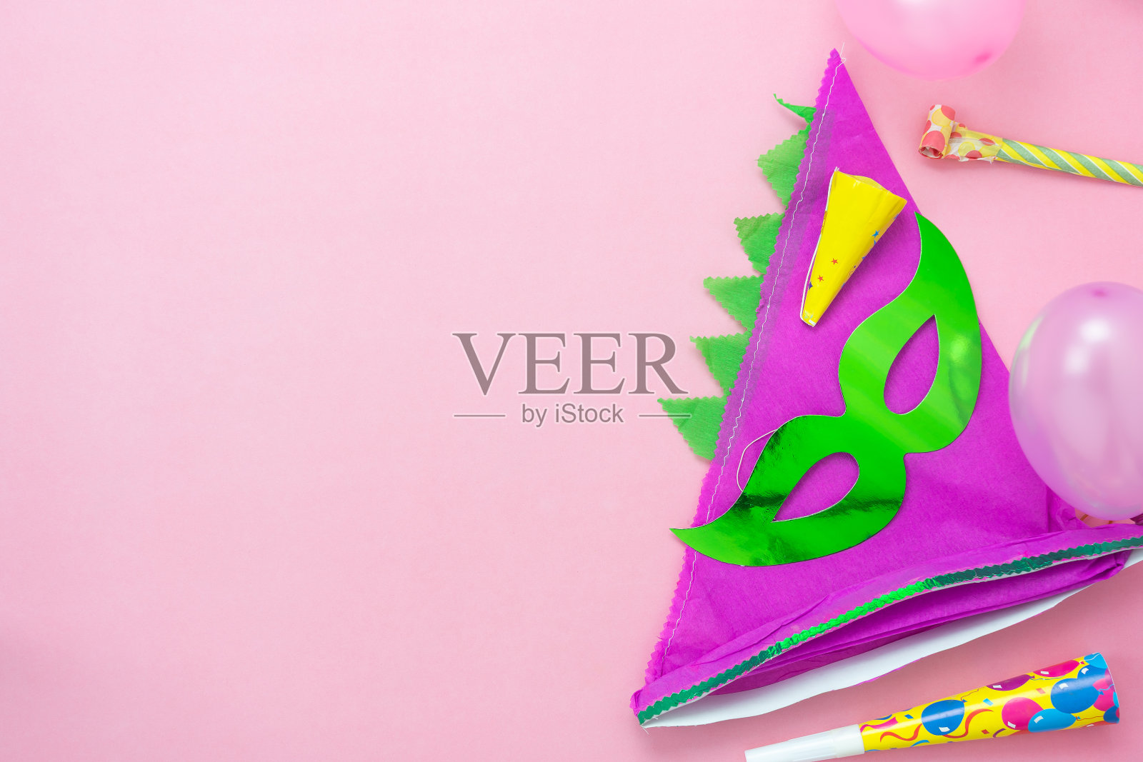 桌面俯瞰航拍图像的美丽多彩的狂欢节季节或照片亭prop Mardi Gras背景。平铺物体彩色的绿色面具与装饰派对上粉红色的纸。空间的文本照片摄影图片