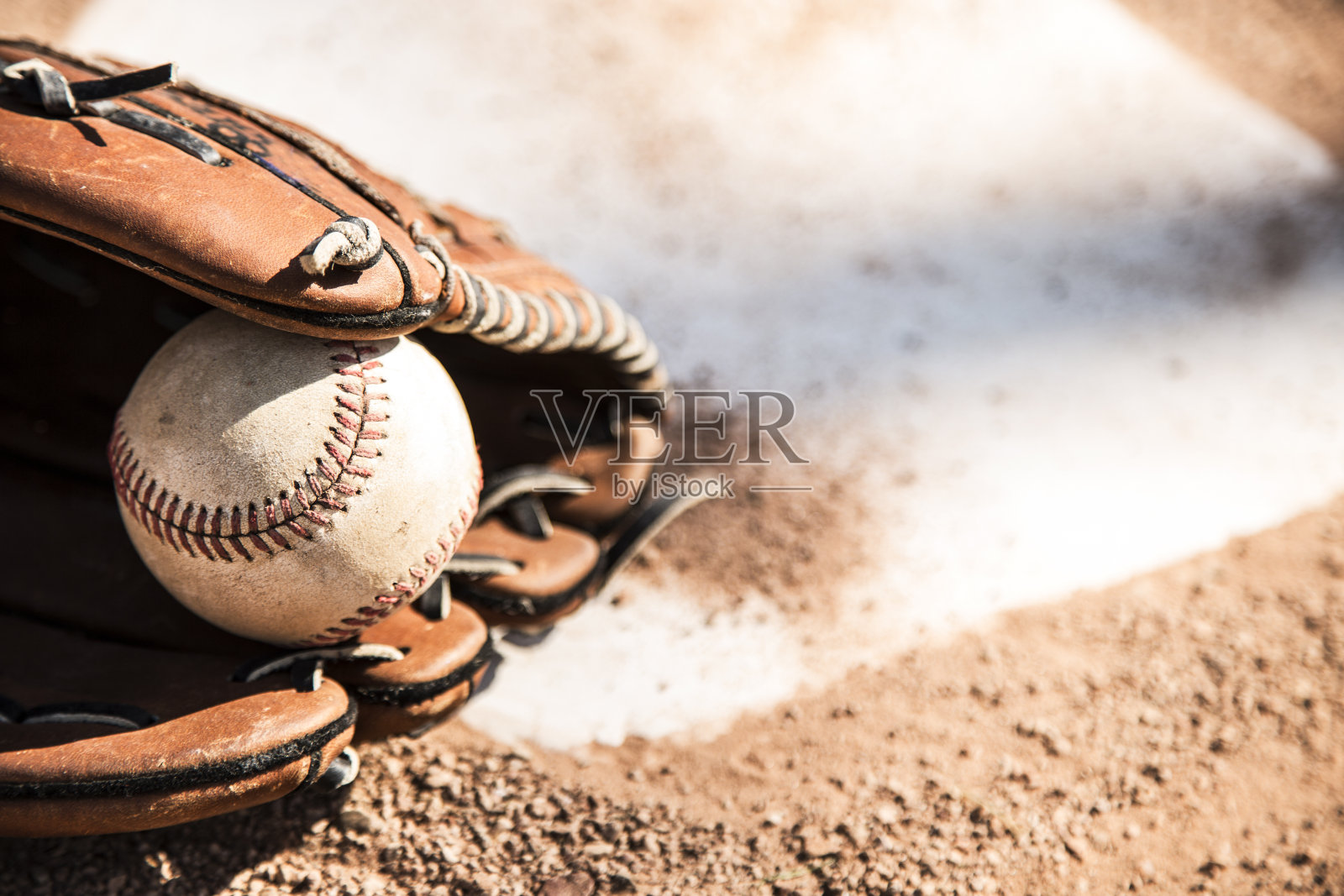 棒球赛季到了。手套和球放在本垒板上。照片摄影图片