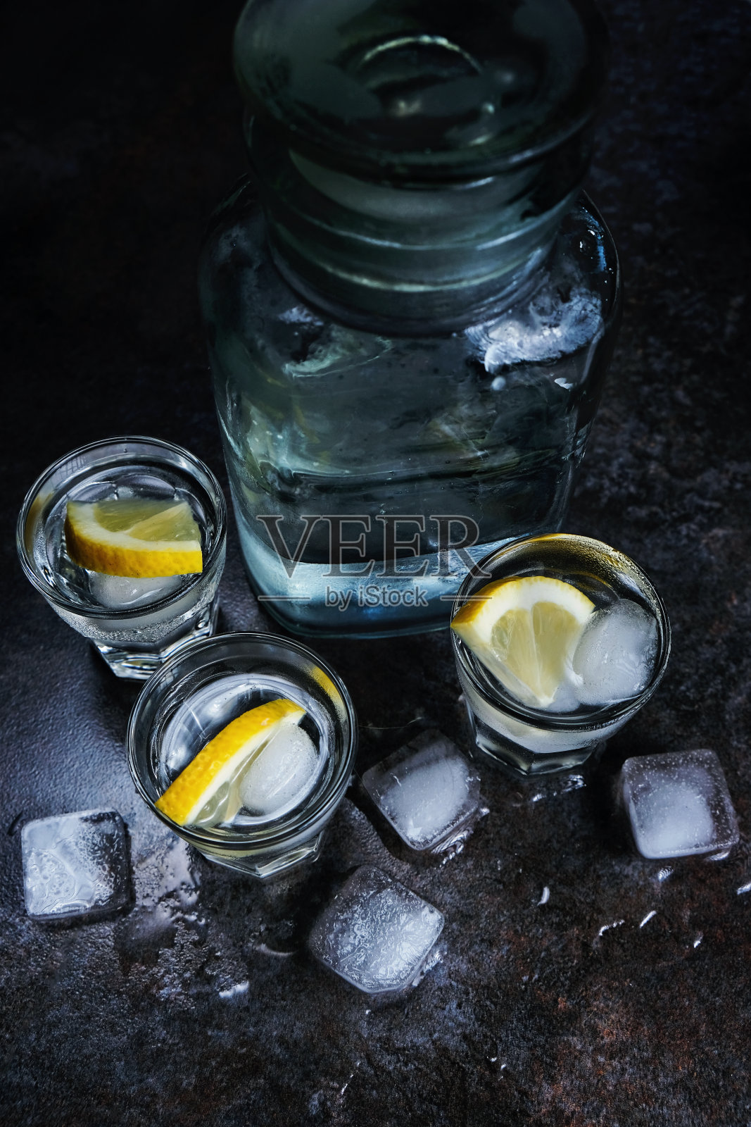 伏特加。伏特加，柠檬和冰块。深色石头背景。垂直的图像。照片摄影图片