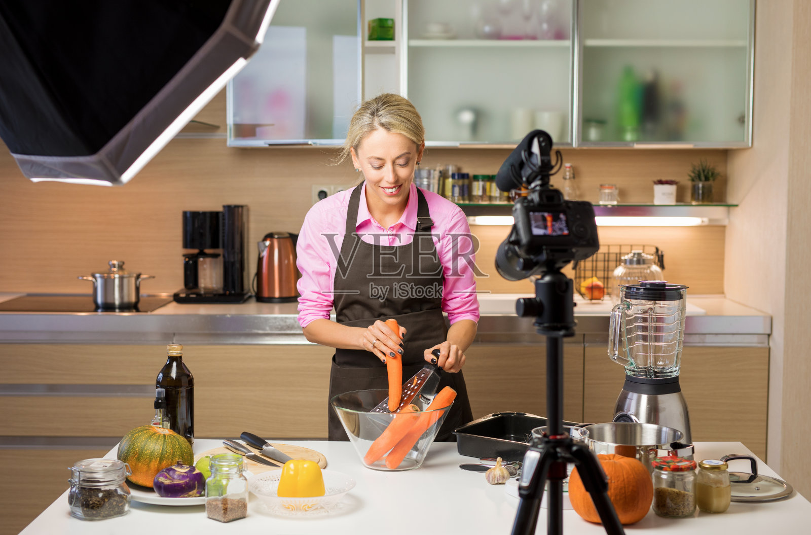 一个女人在拍摄烹饪视频博客。视频博客、博客和内容创作的概念。照片摄影图片