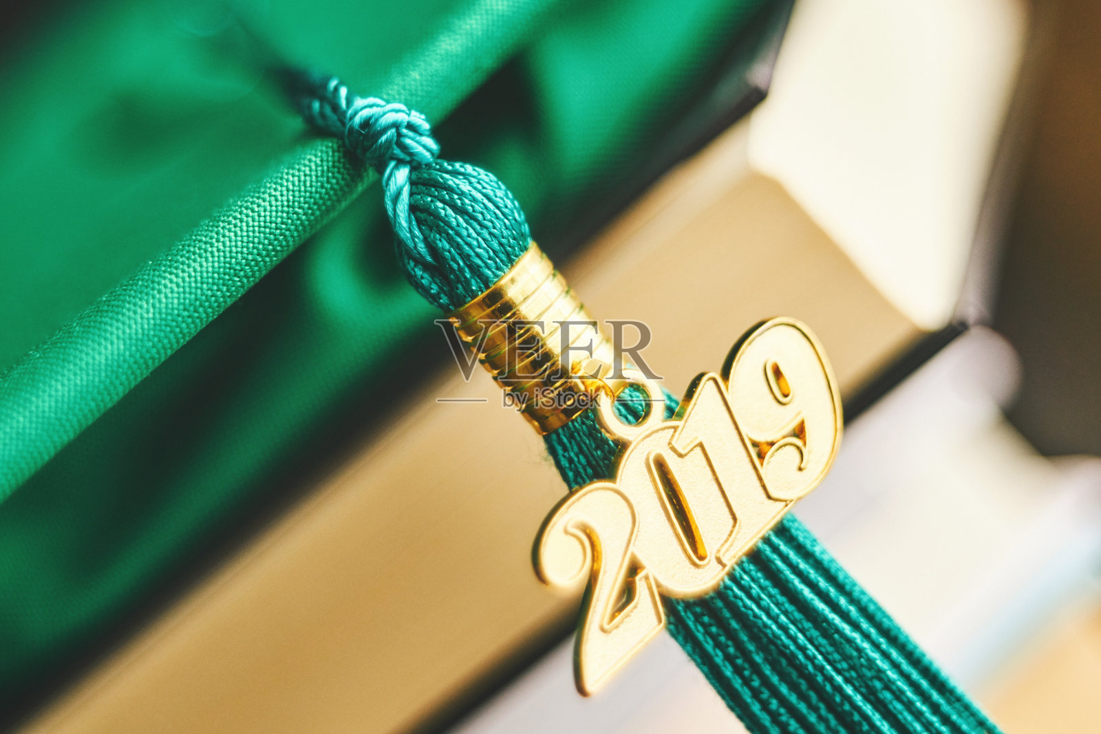 带2019年毕业流苏和书籍的绿色学士帽照片摄影图片