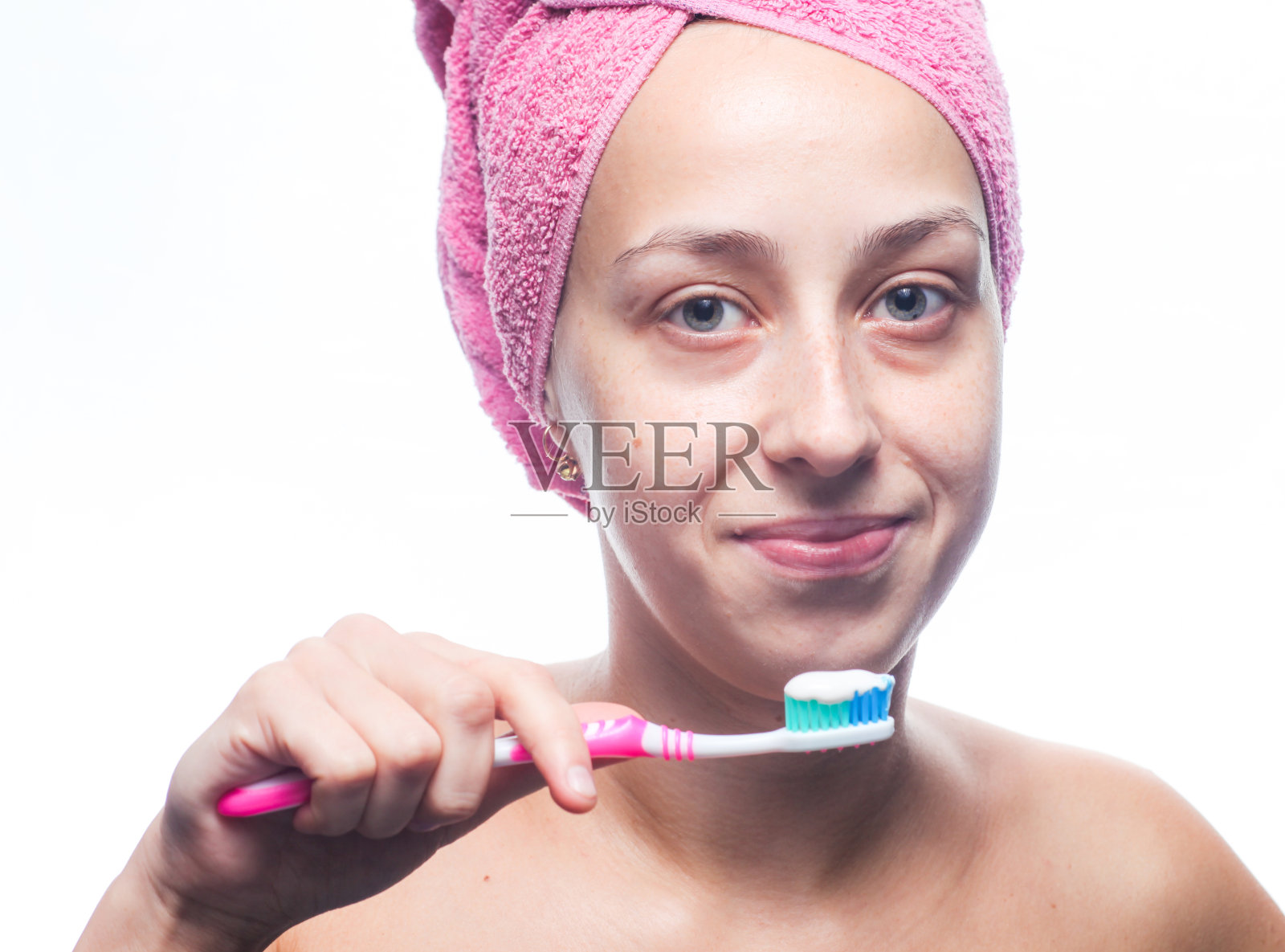 一个用毛巾顶着头刷牙的漂亮女人。早上的治疗方法照片摄影图片