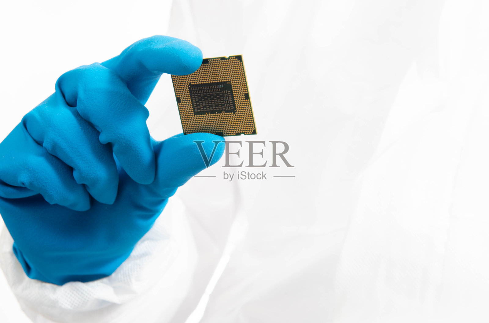 电子制造工厂设计工程师在无菌工作服拿着微芯片和手套并检查它，纳米技术概念照片摄影图片