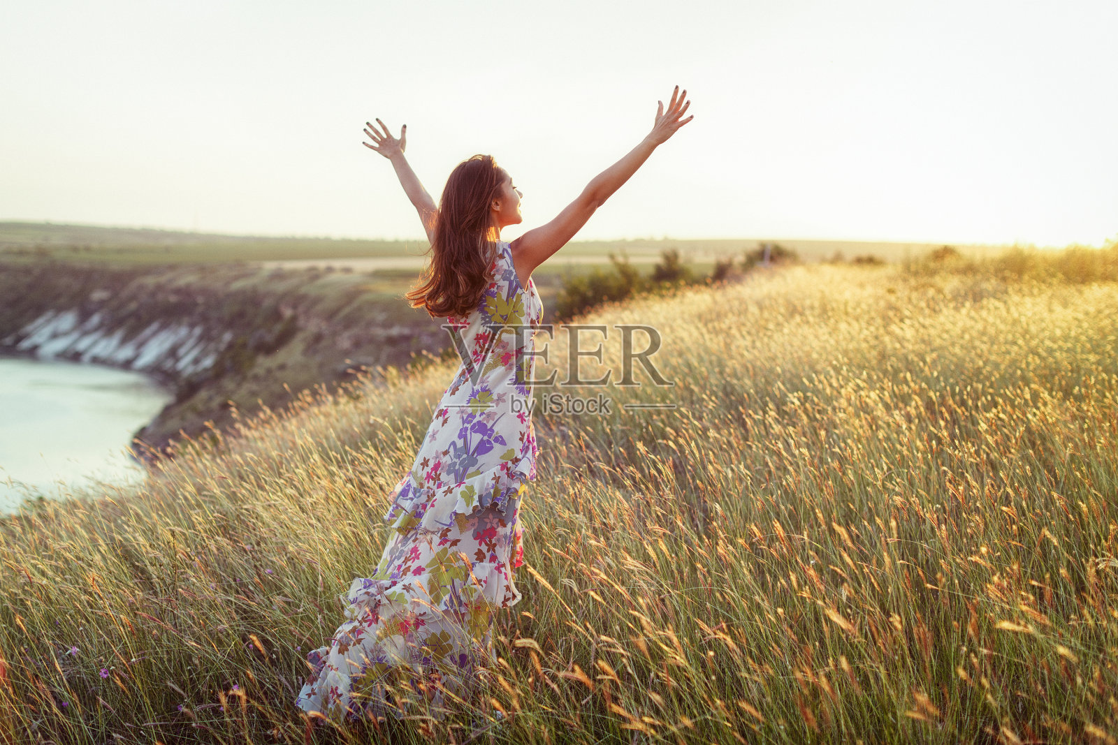 快乐的女人穿着轻装站在草地上照片摄影图片