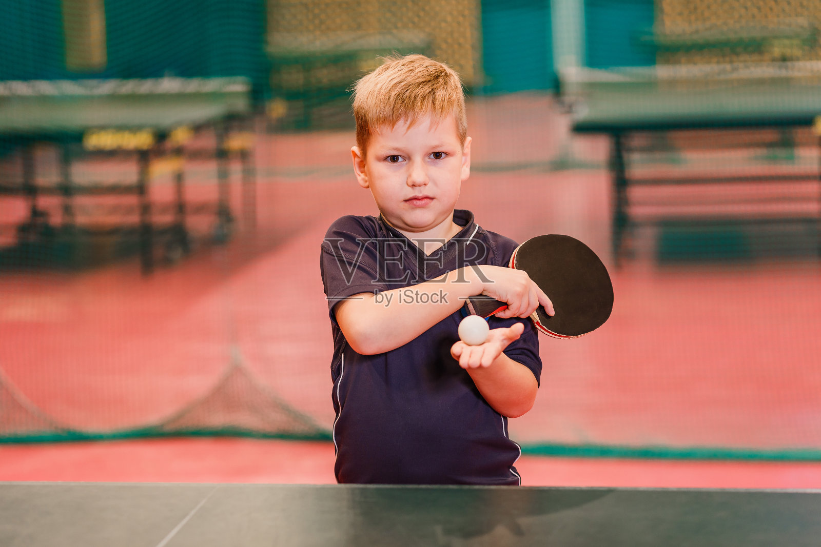 在体育馆里拿着球和火箭的儿童乒乓球运动员照片摄影图片
