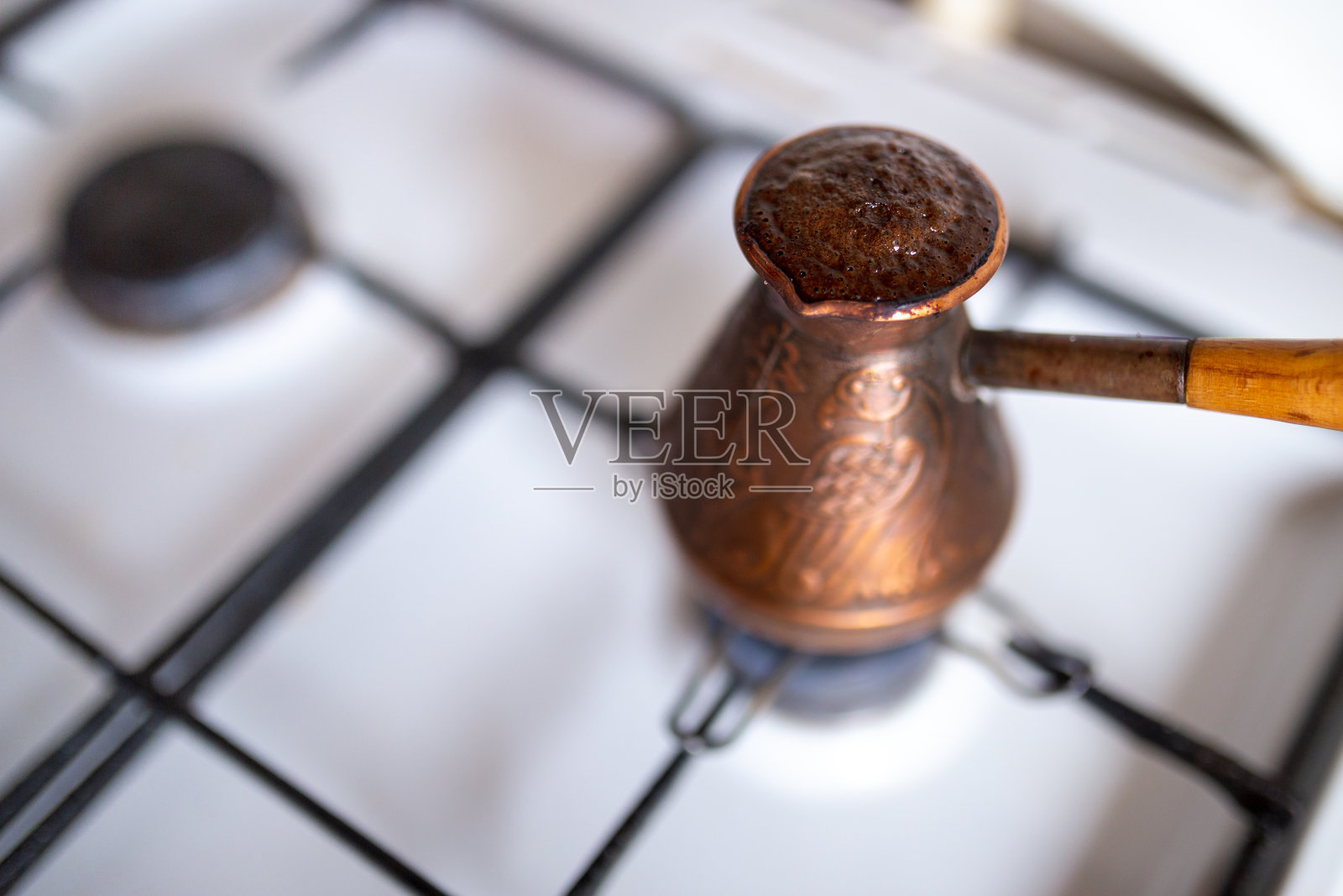 非常热的咖啡帽-咖啡在一个舒适的典型厨房的煤气炉上在铜cezve煮在早上照片摄影图片