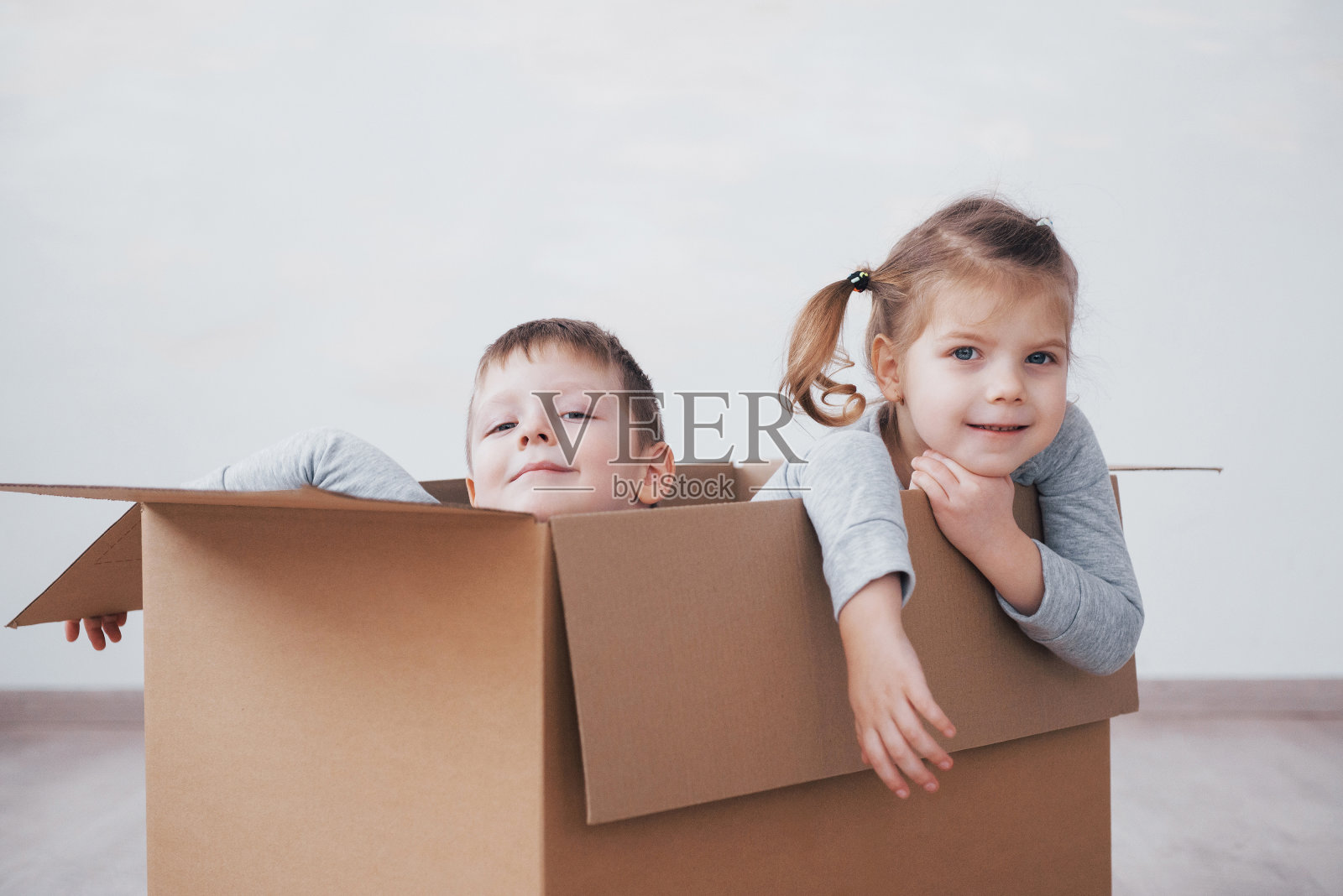 小弟弟和小妹妹在托儿所的纸箱里玩耍照片摄影图片