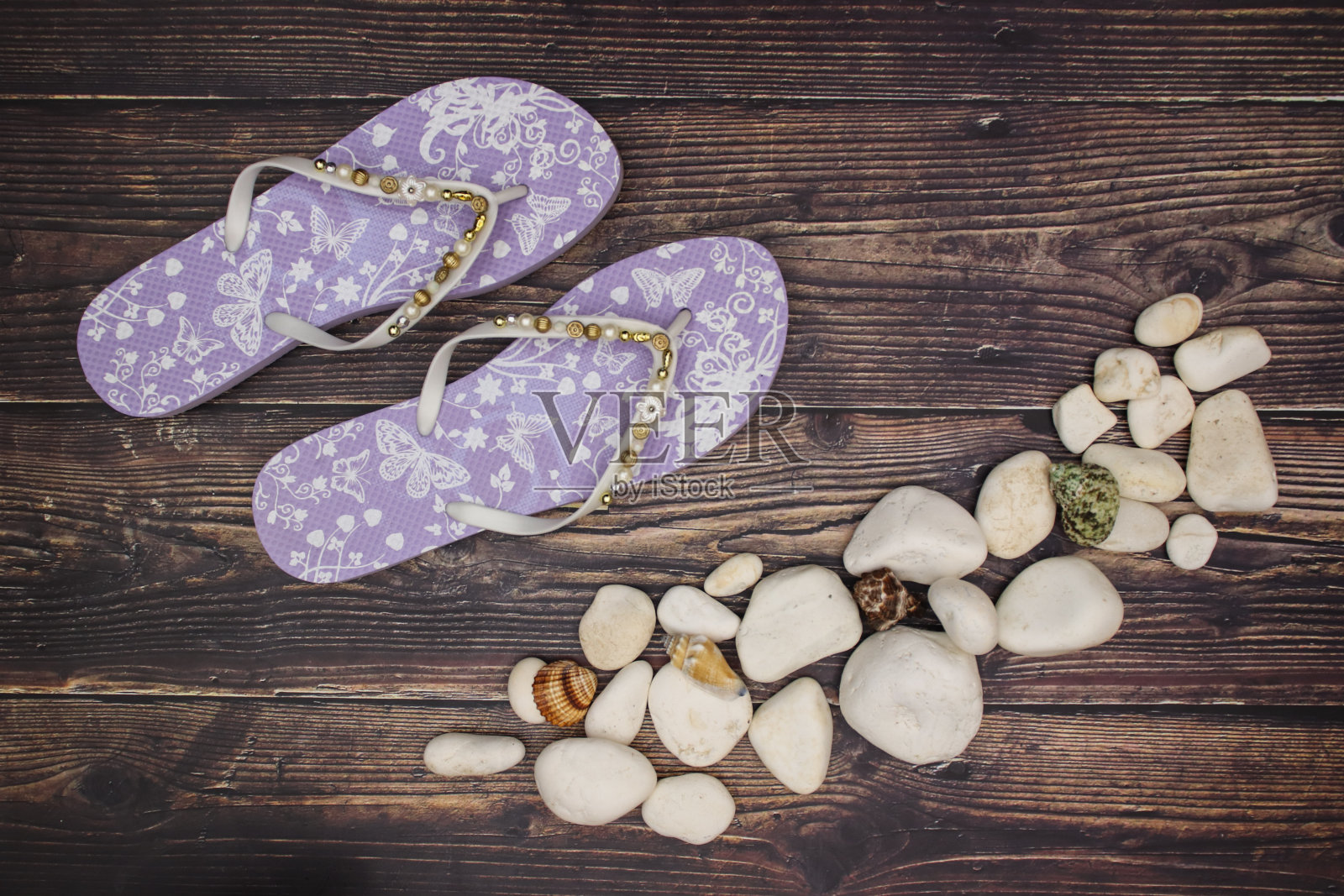 岩石，贝壳和紫色拖鞋在木制的背景照片摄影图片