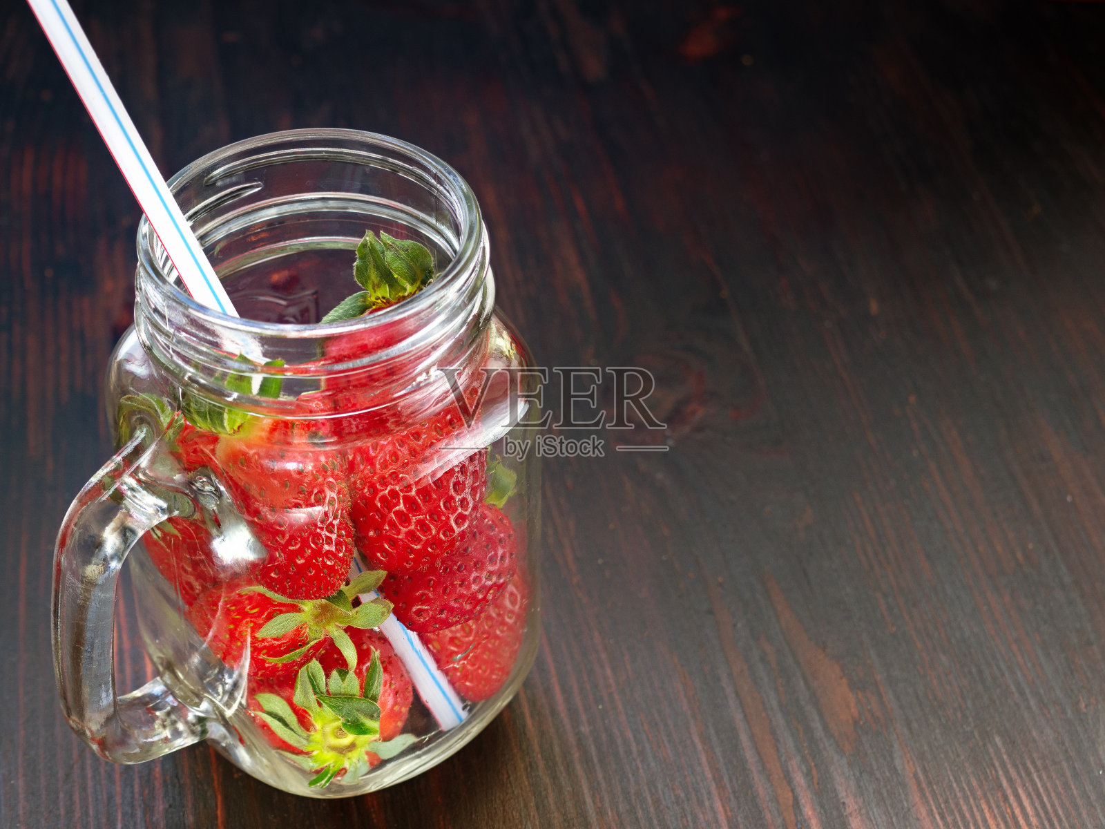 新鲜草莓冰沙在罐子上的木材背景照片摄影图片