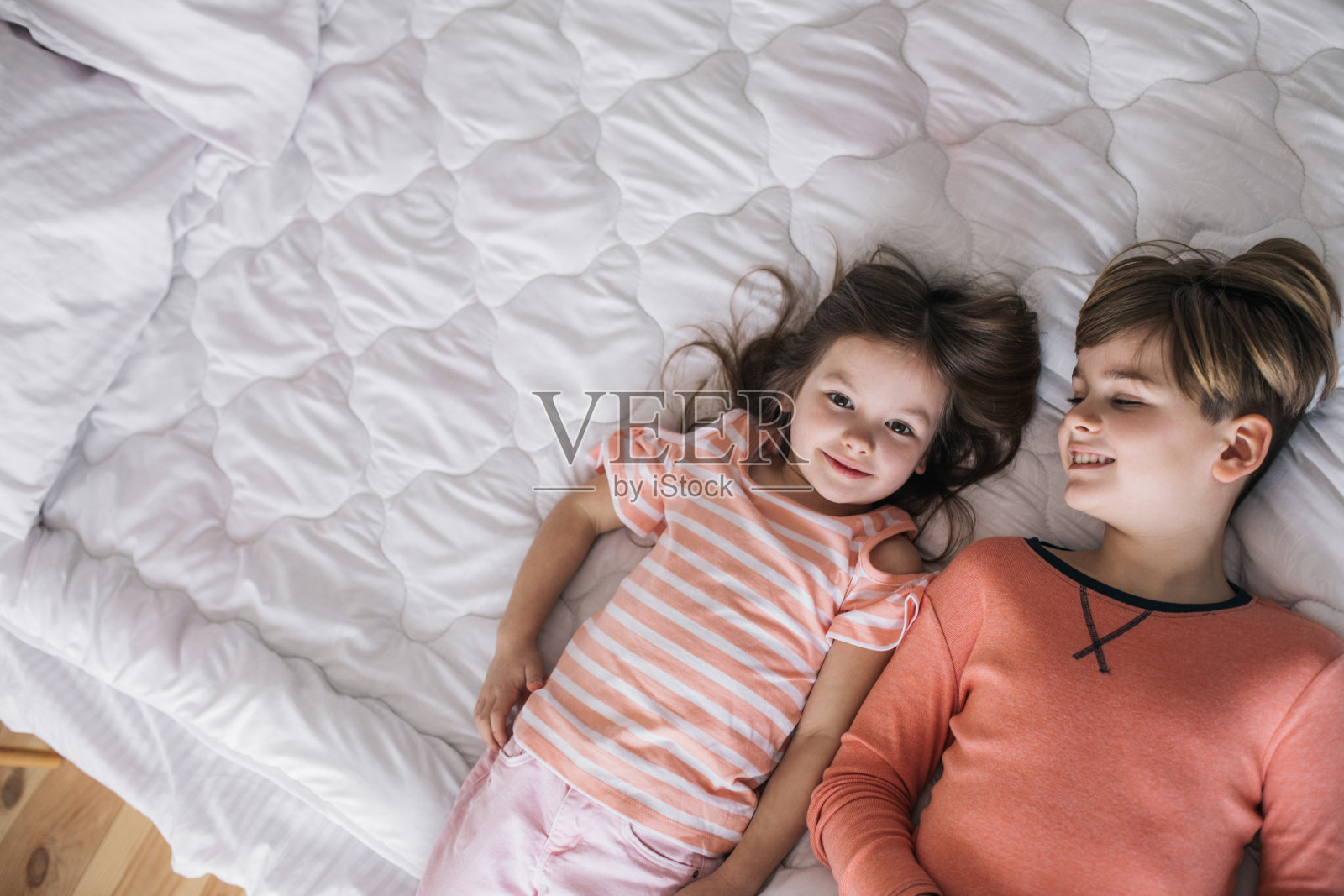 俯视图快乐的孩子们躺在奶奶家的床上照片摄影图片