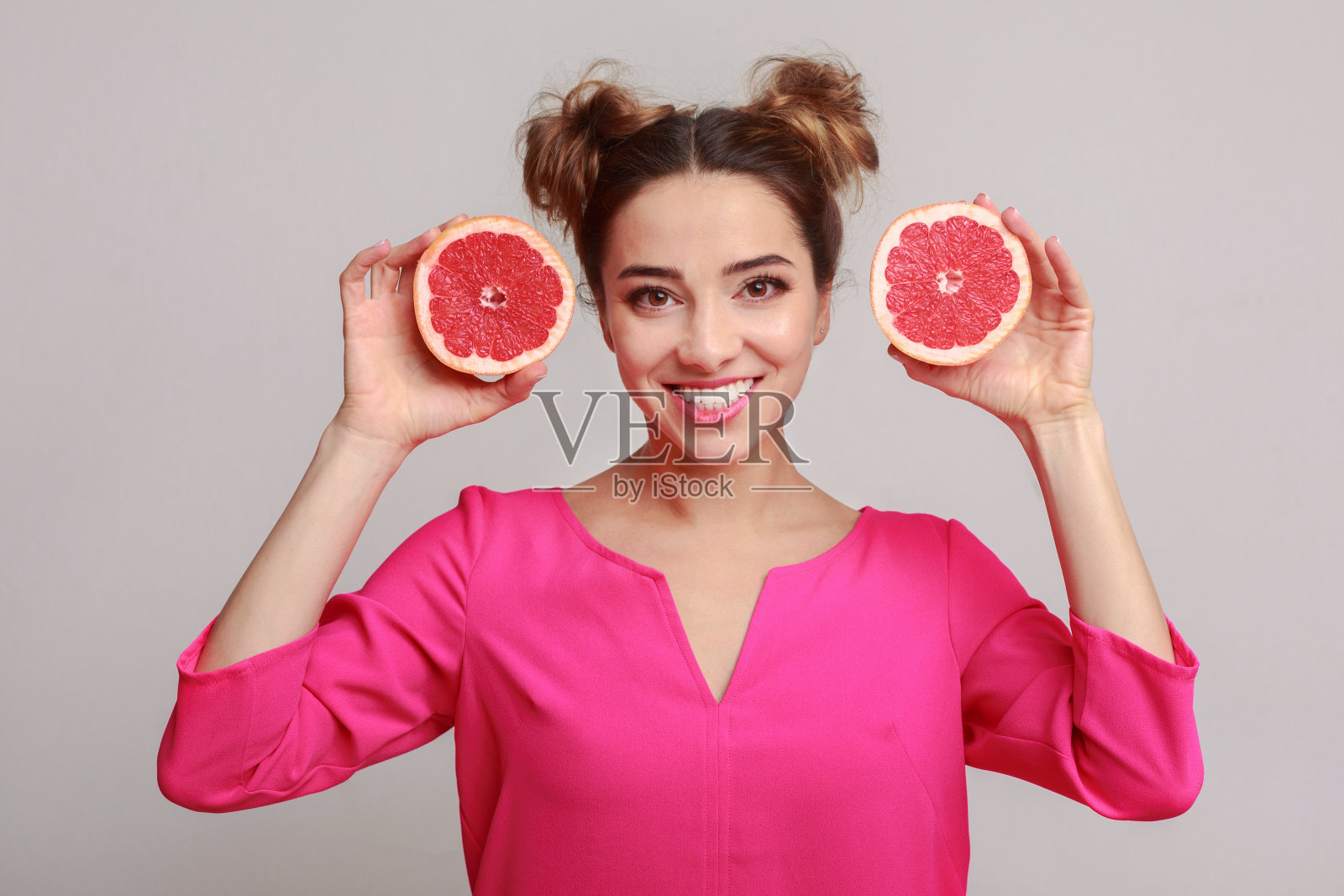 快乐的女人，背靠半片葡萄柚照片摄影图片