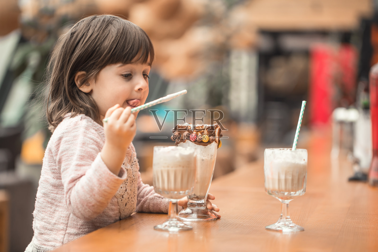 可爱有趣的小女孩喝着奶昔照片摄影图片