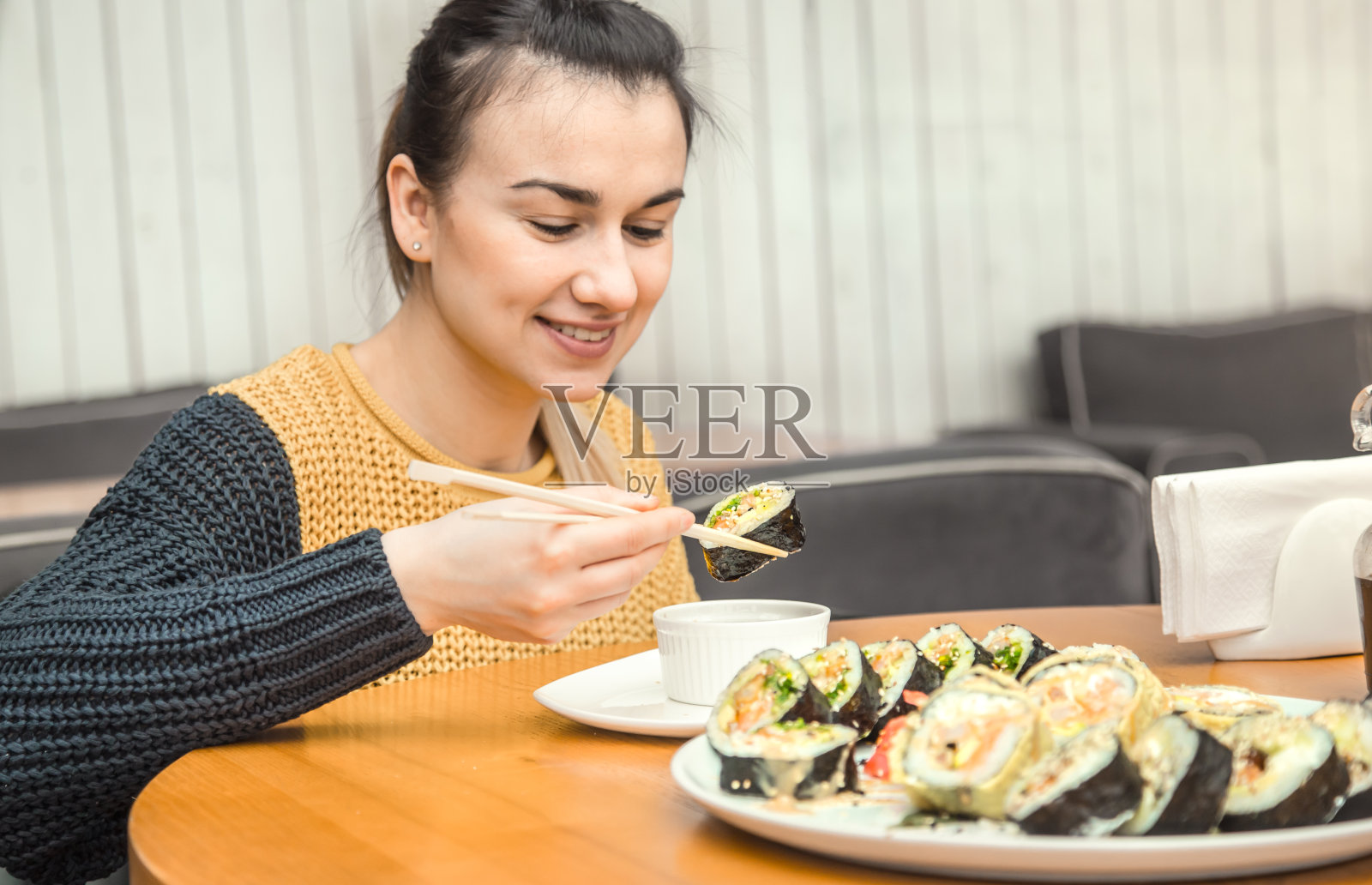 年轻女子正在享用新鲜的寿司照片摄影图片