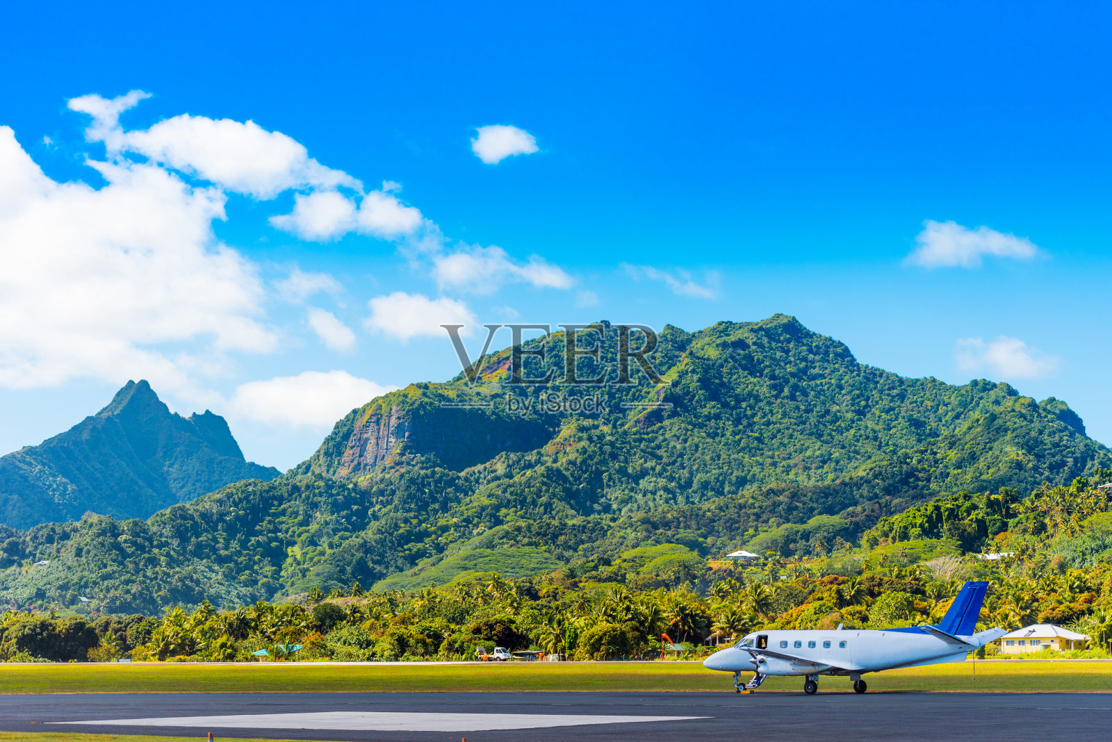 这架飞机在机场的背景是库克群岛的艾图塔基岛的山景。文本复制空间照片摄影图片