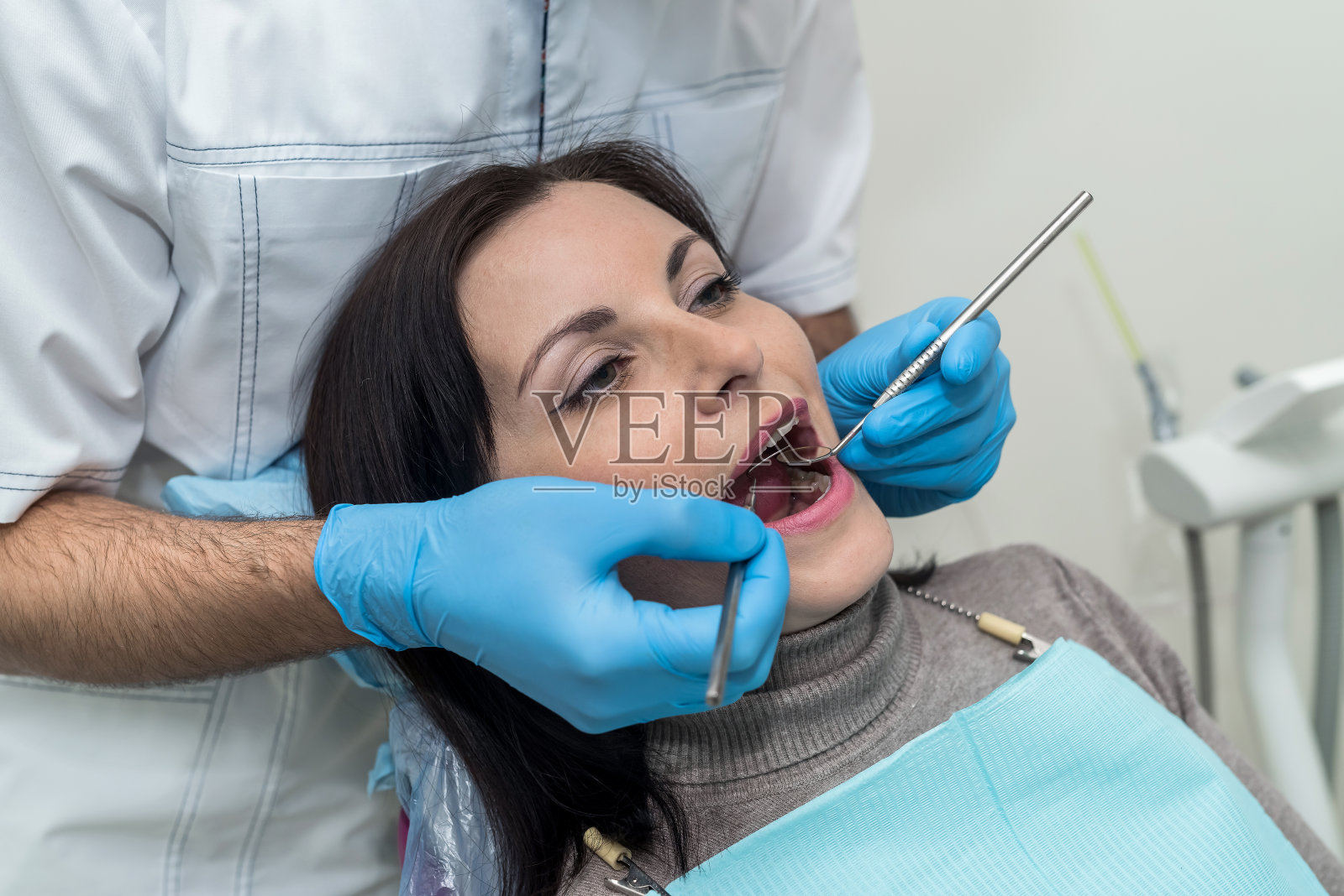 牙科医生用工具检查病人的牙齿照片摄影图片