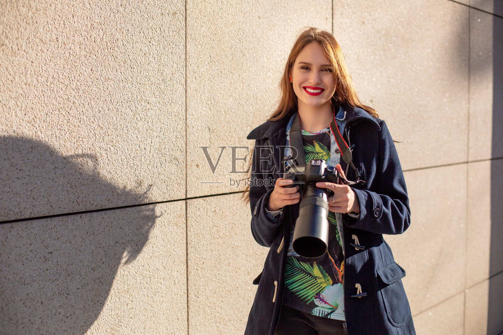 职业女摄影师在街头用相机拍摄肖像。照片摄影图片