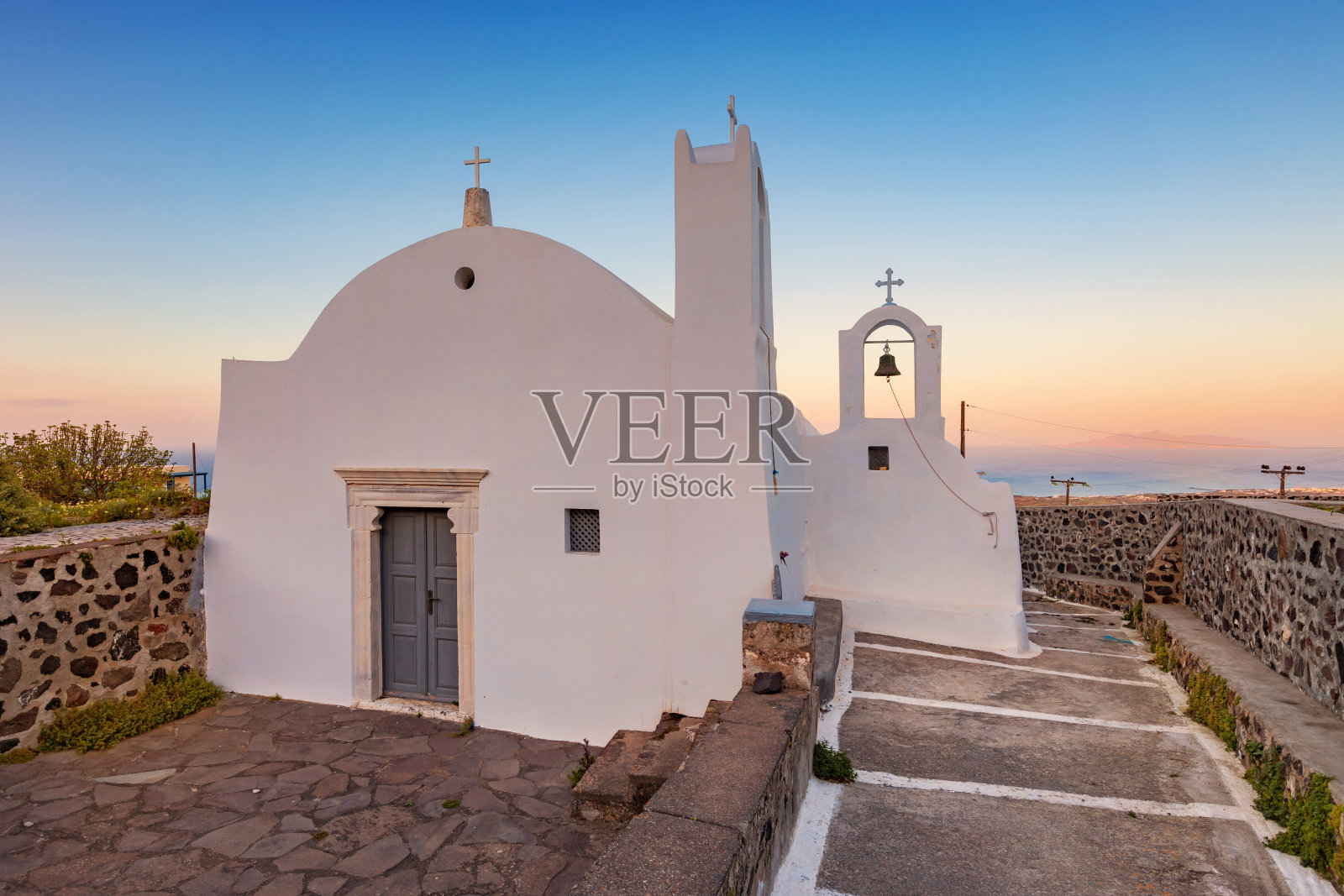 日落时希腊圣托里尼岛的教堂照片摄影图片