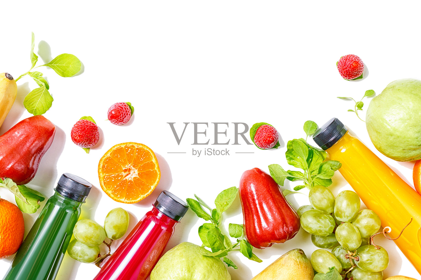 美丽的彩色果汁瓶与热带水果边境孤立在白色的背景。Vegetarion食品的概念。排毒照片摄影图片
