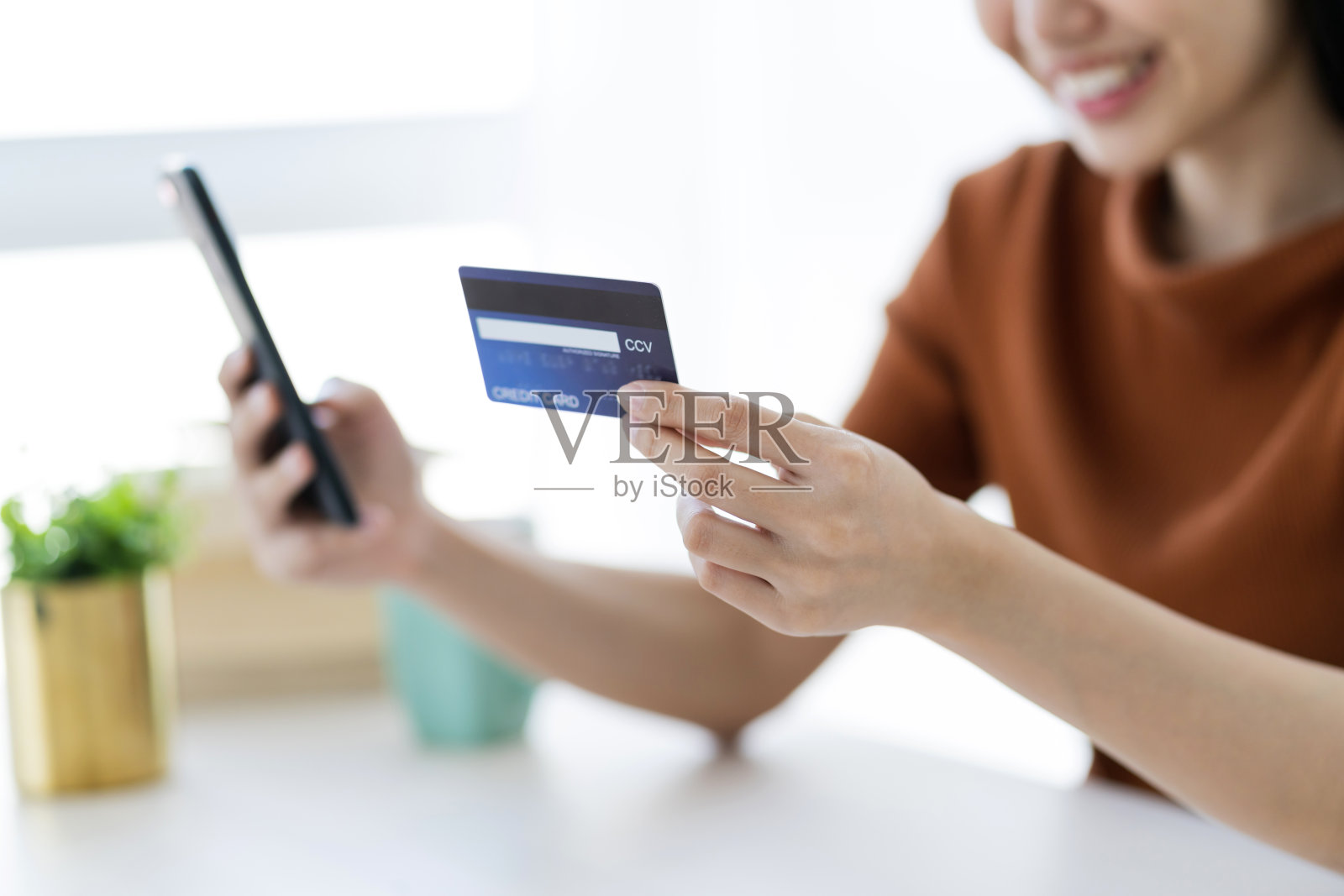 美丽的亚洲女人手握信用卡和智能手机网上购物的经营理念照片摄影图片