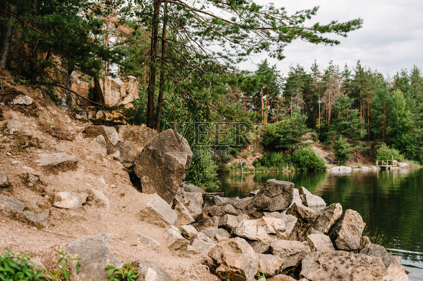 石头落入水中。湖的背景是岩石和冷杉树。峡谷。放置文本和设计。这是一个充满水的古老花岗岩采石场。照片摄影图片