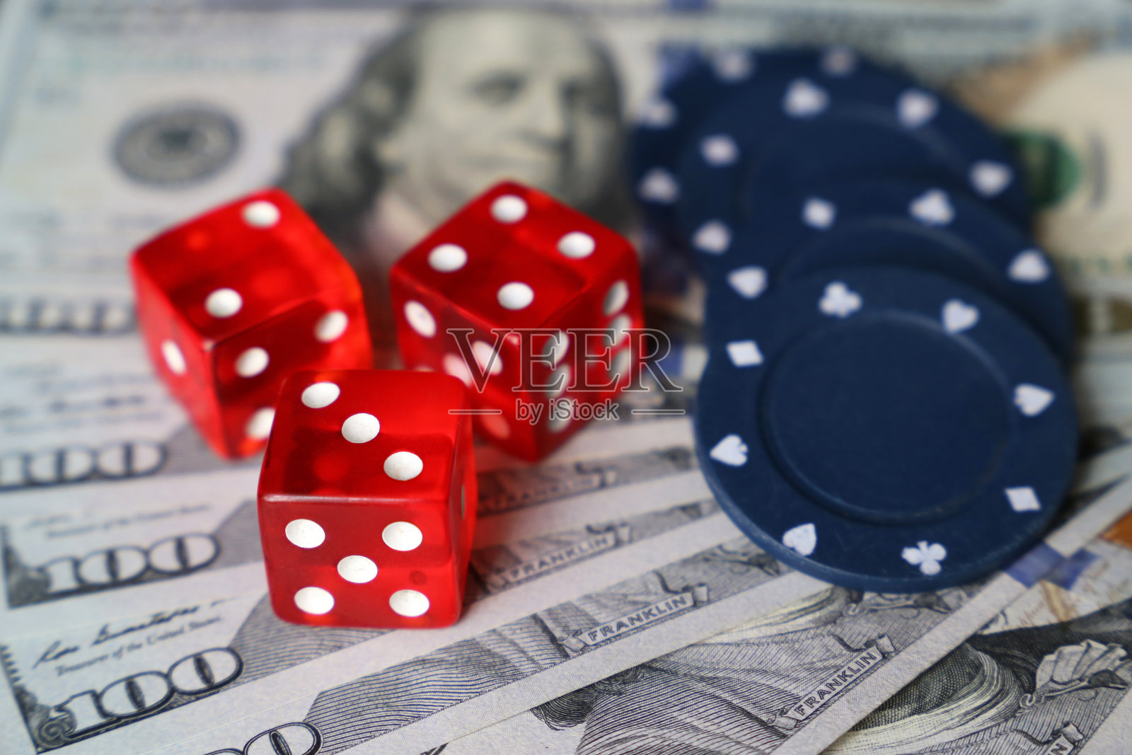 美元钞票上的红色骰子和赌场筹码照片摄影图片