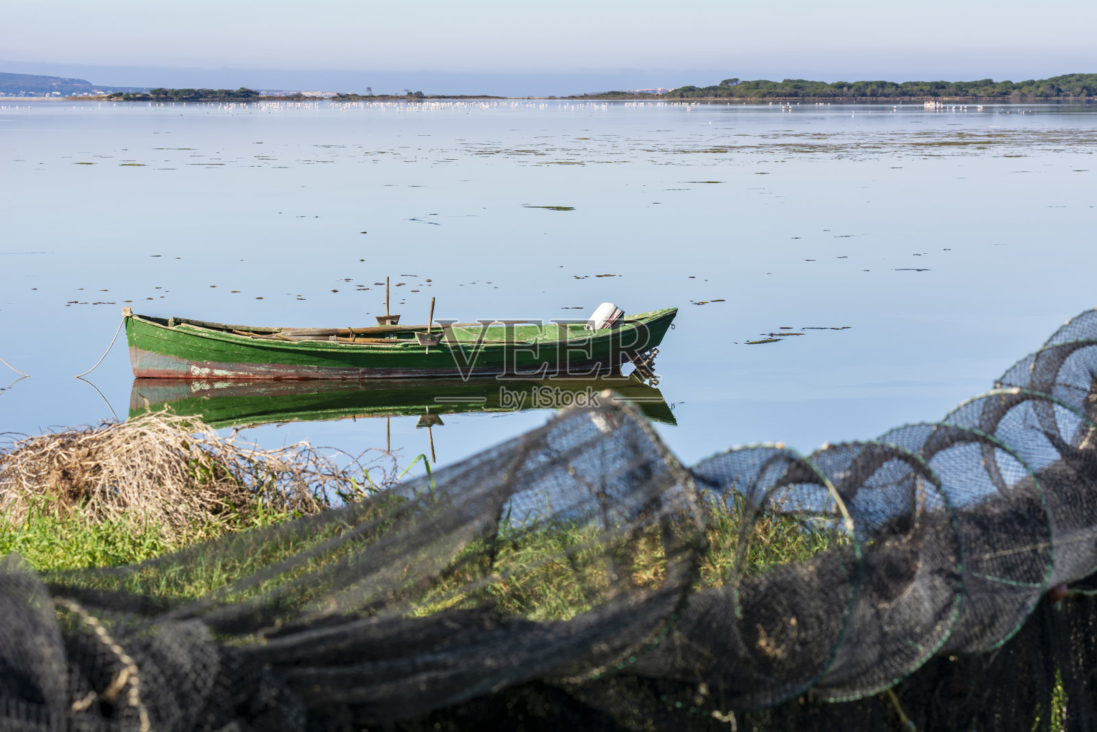 黎明时分湖面上色彩鲜艳的旧渔船。照片摄影图片
