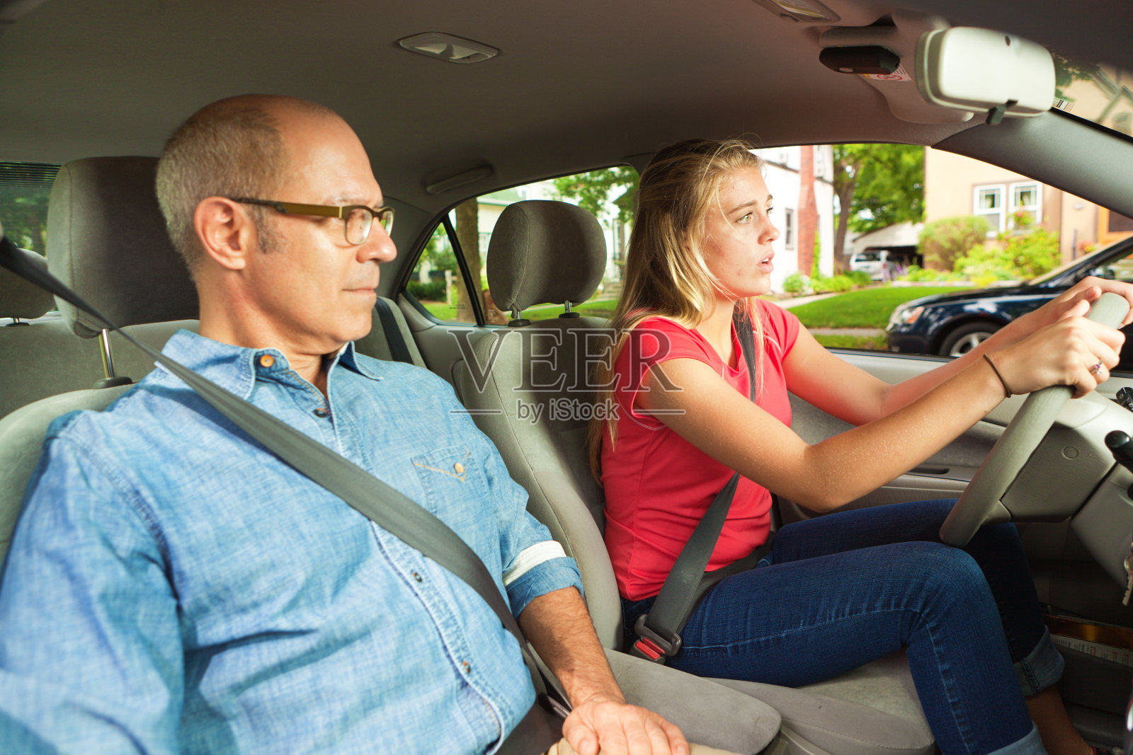 青少年学生司机驾驶与成人，父母，或父亲在乘客座位照片摄影图片