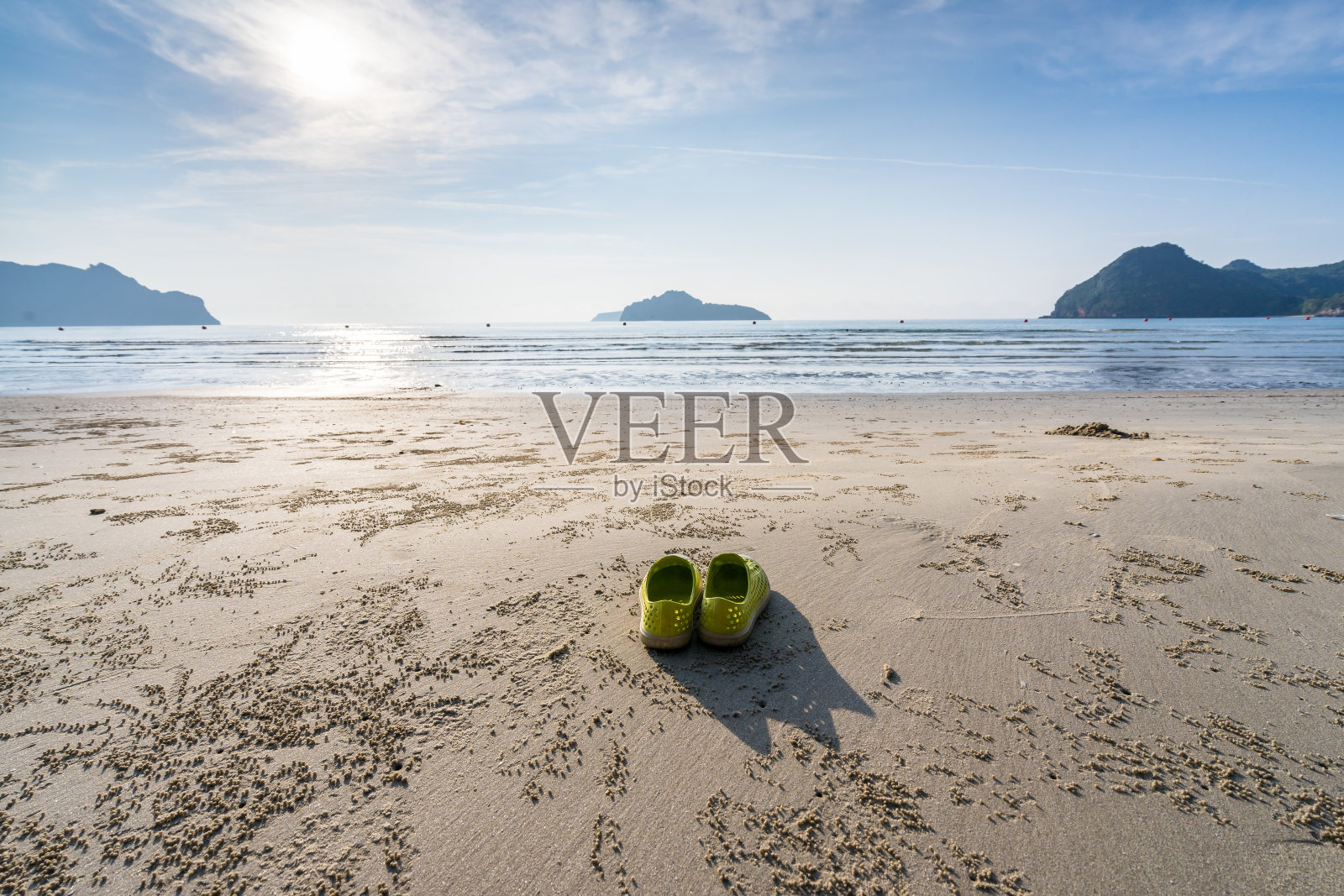 夏日清晨，黄色的鞋子摆放在泰国普拉丘普·基里汗的海滩边照片摄影图片