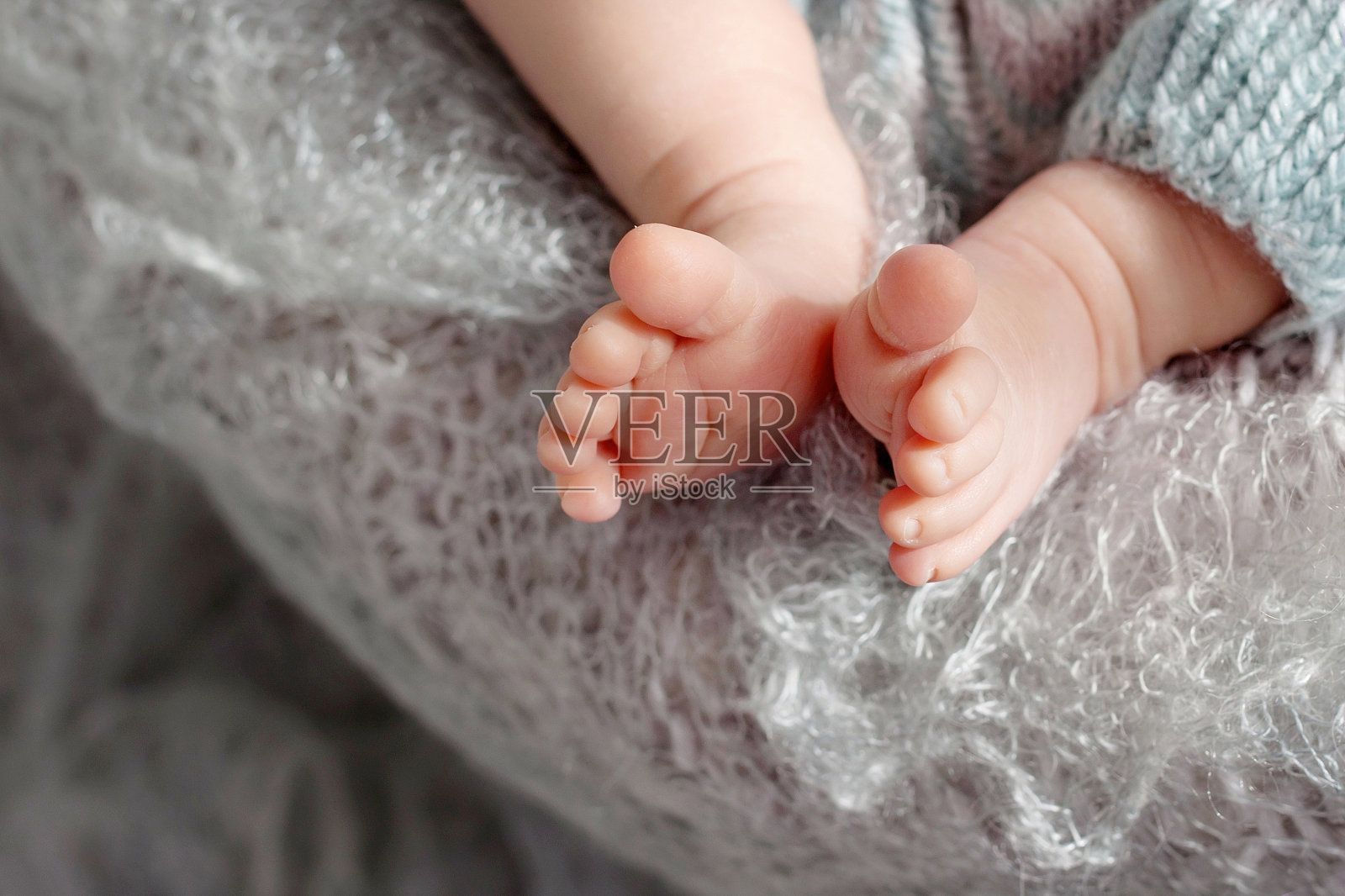 特写照片的新生婴儿的脚针织格子。美丽的母性概念形象照片摄影图片