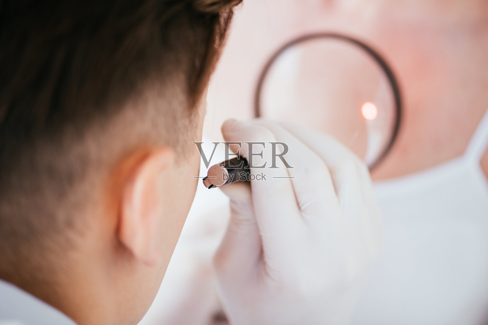 近距离观察皮肤科医生拿着放大镜与黑色素瘤妇女照片摄影图片