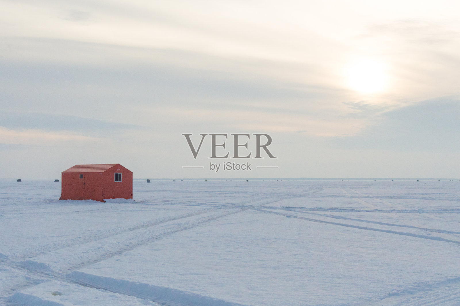 日落时分，安大略冰冻湖面上的冰上钓鱼小屋照片摄影图片