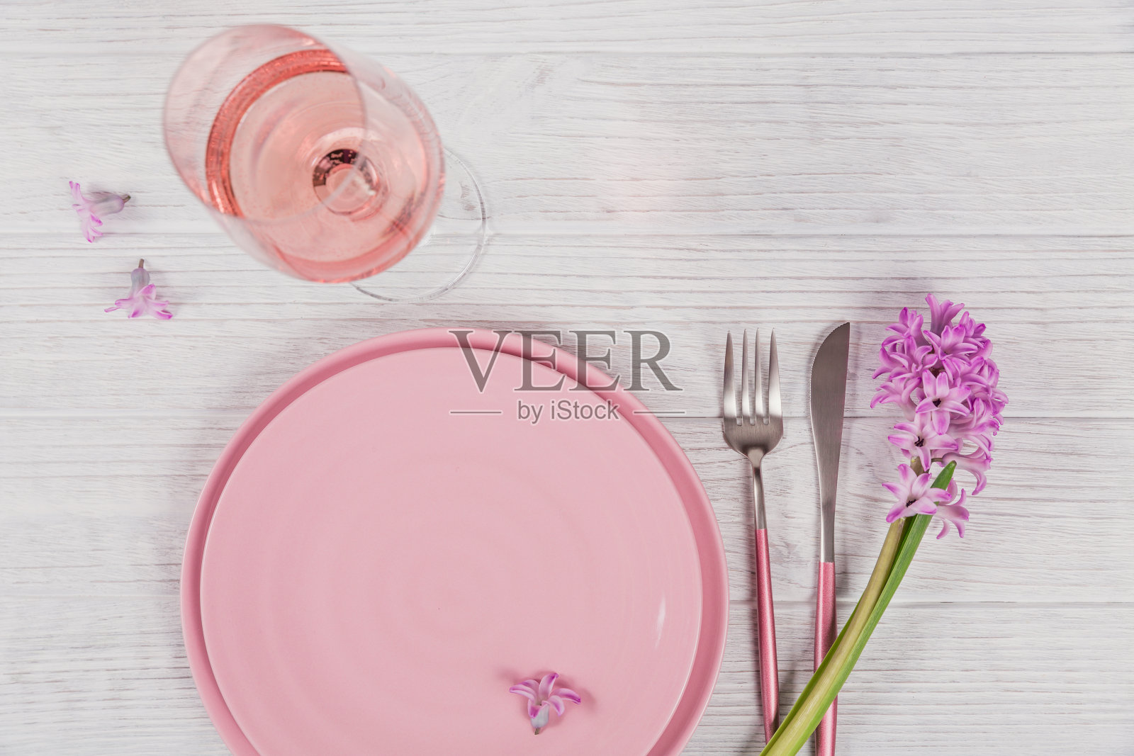 粉红色的乡村场所，以紫色的风信子花和亚麻餐巾和一杯玫瑰葡萄酒在白色的木制背景照片摄影图片